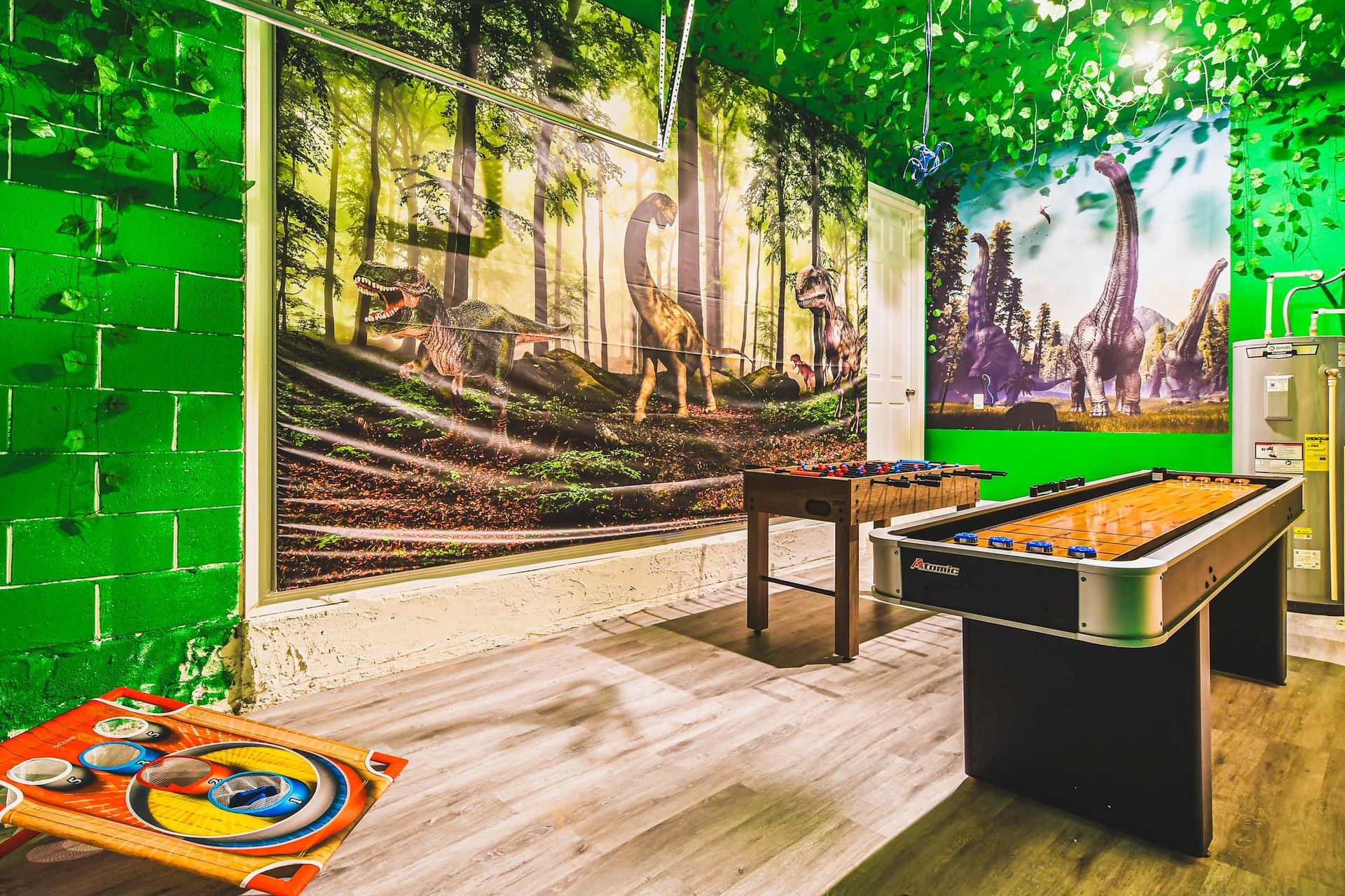 Dinosaur-themed game room with foosball, shuffleboard, and climbing fun.