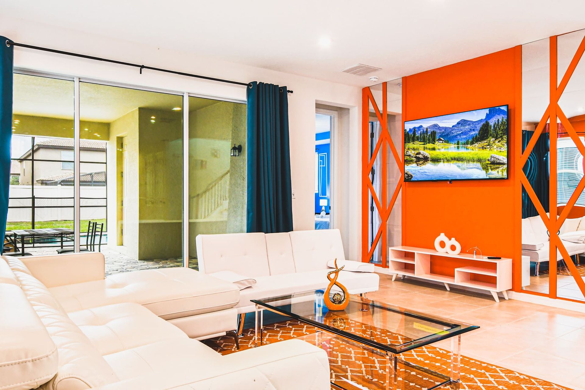 Vibrant living room with bold decor, comfy seating, and poolside patio access.