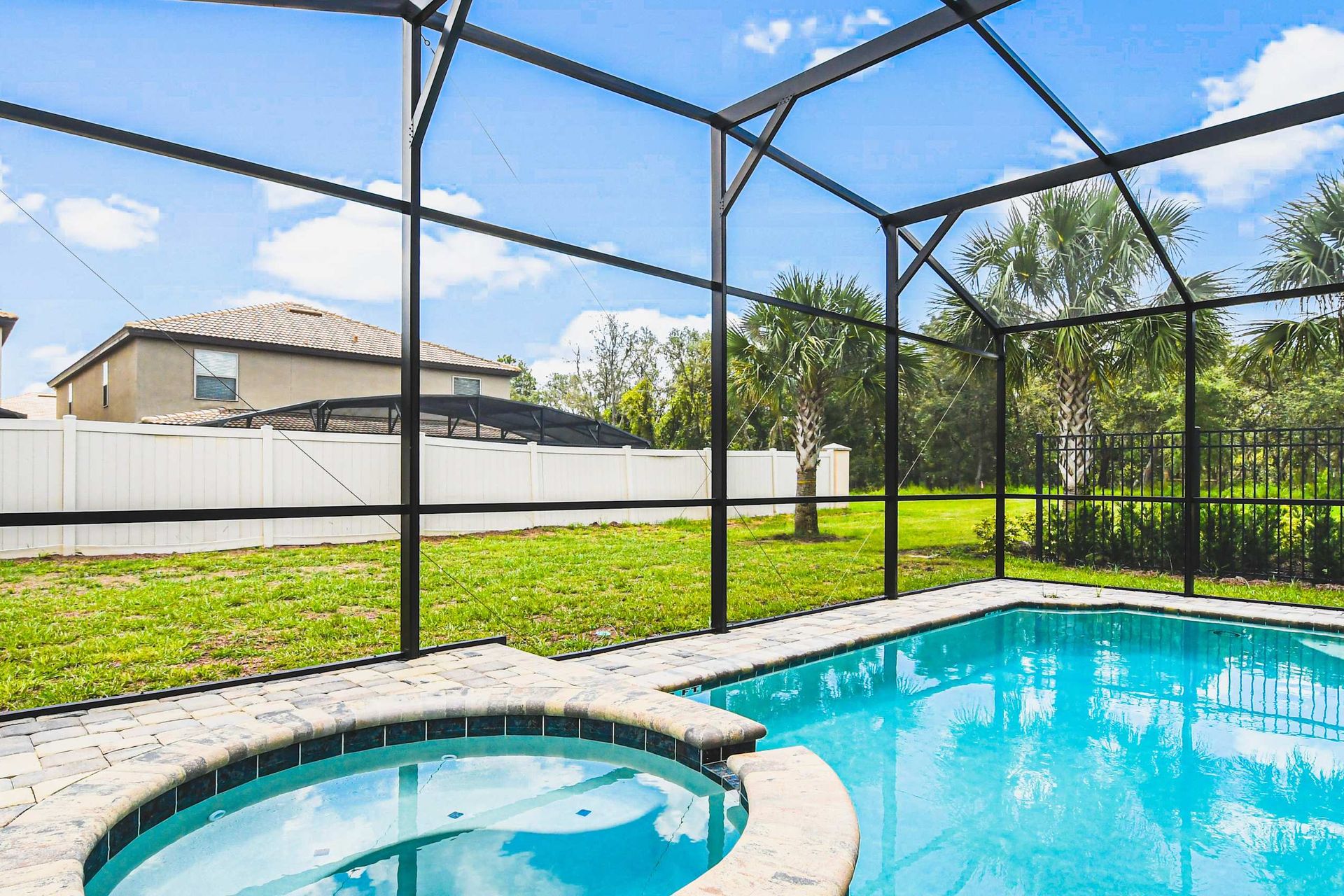 Relax in a private screened pool and spa with palm-lined views and sunny skies.