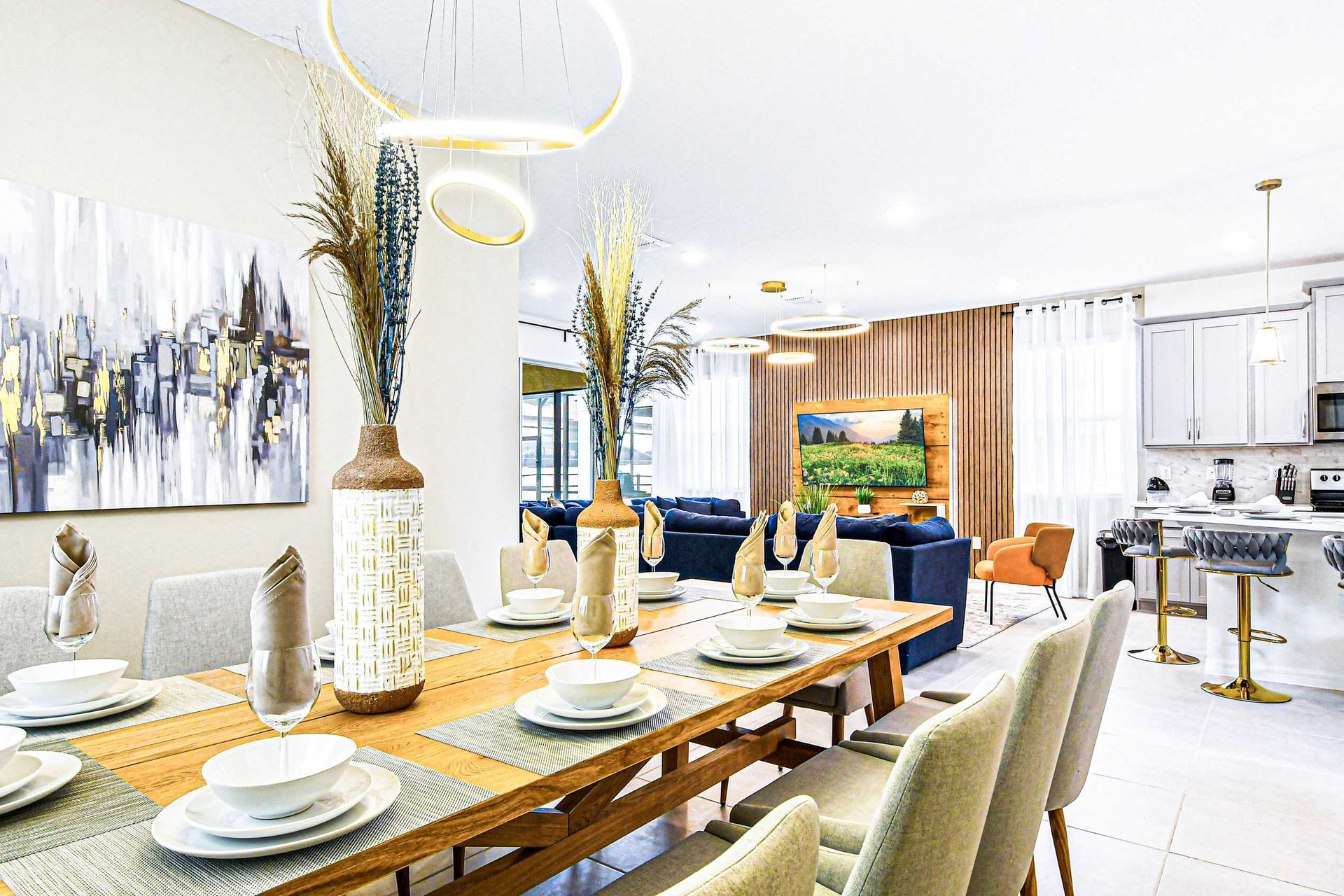 Elegant dining area with modern decor, open kitchen, and natural light.
