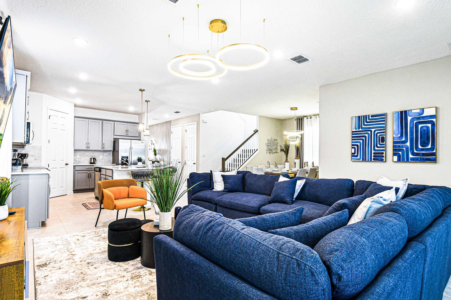 Modern open-concept living area with cozy seating, elegant lighting, and decor.