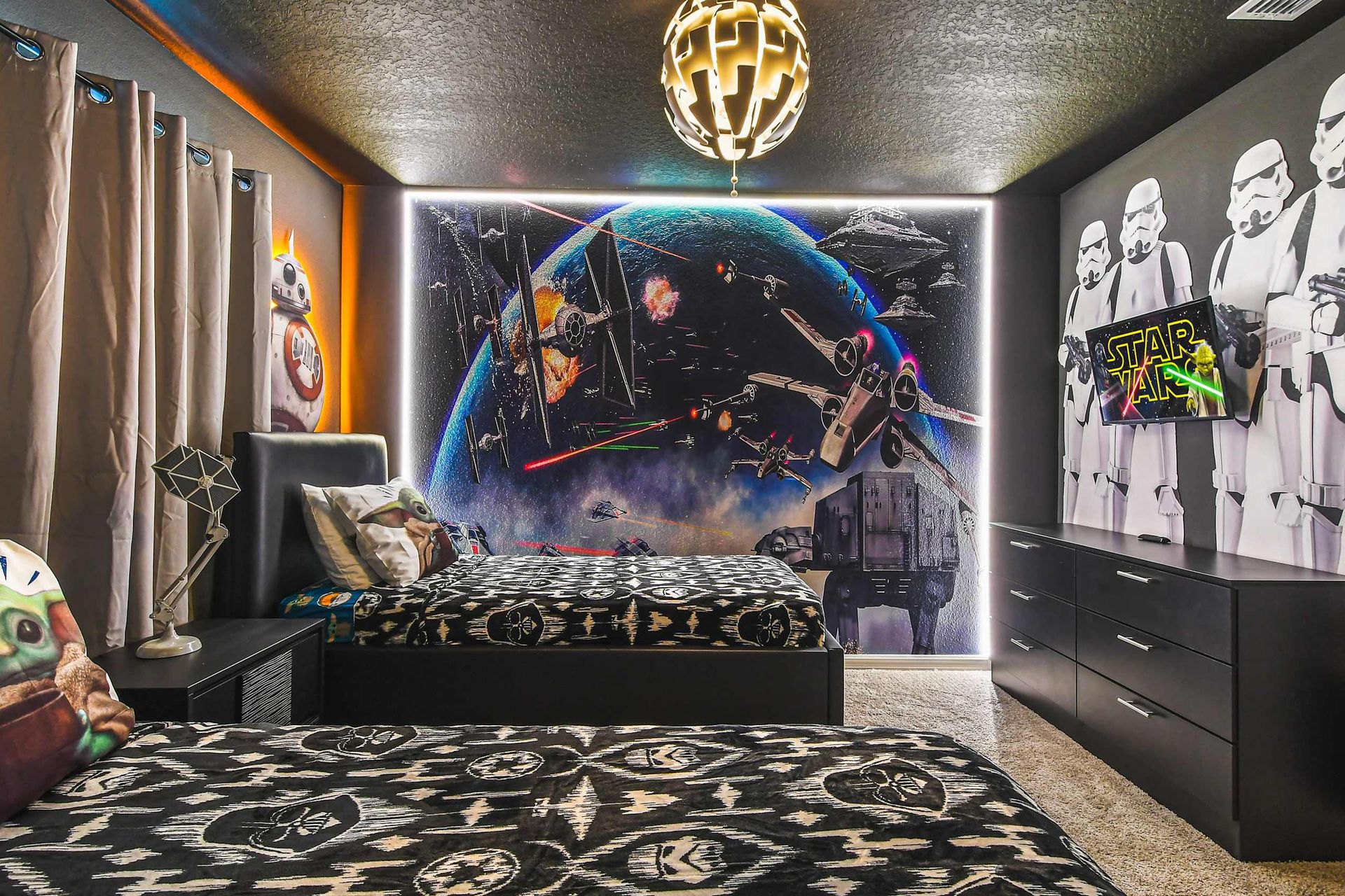 Epic Star Wars themed twin room with galaxy mural and out-of-this-world vibes!
