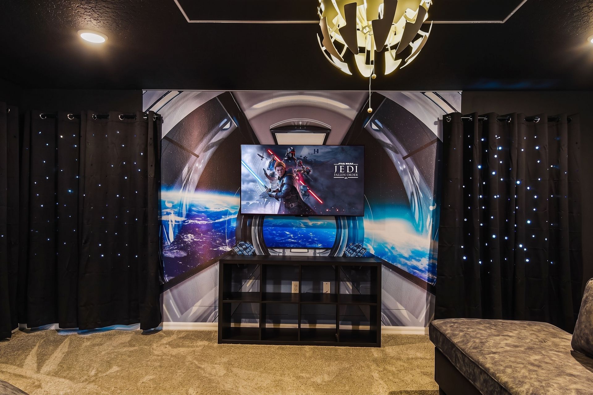 Thrilling game room with space-themed walls, arcade basketball, and gaming setup.