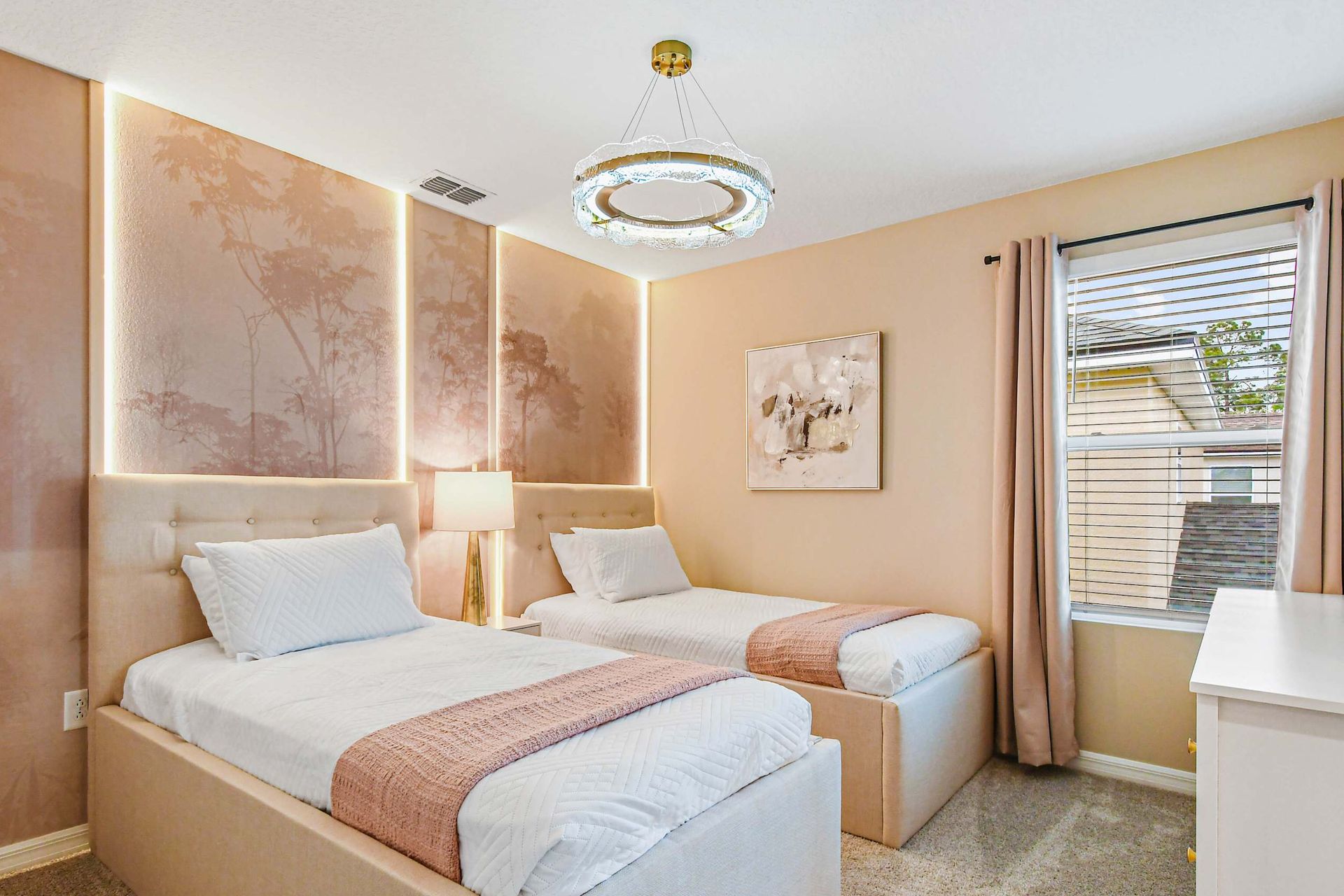 Cozy twin bedroom with soft blush tones, elegant lighting, and serene wall accents.