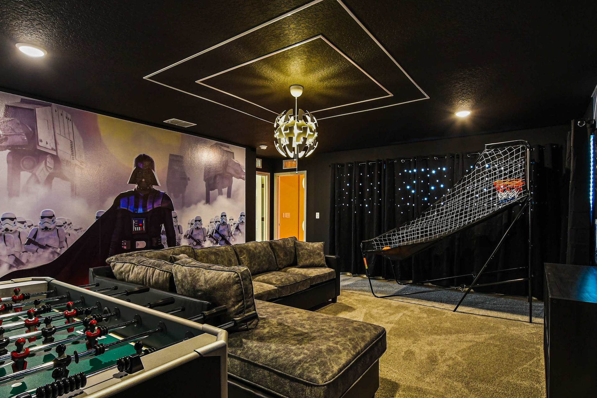 Epic game room with space-themed decor, foosball, basketball, and cozy lounge seating.