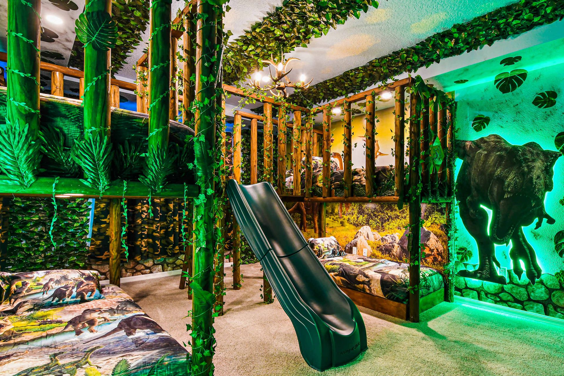 Jurassic bunk room with slide and jungle vibes for epic kids' adventure stays.