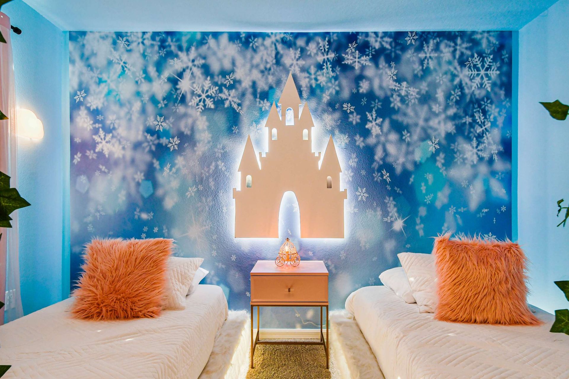 Whimsical twin bedroom with snowflake mural, glowing castle, and cozy pink accents.