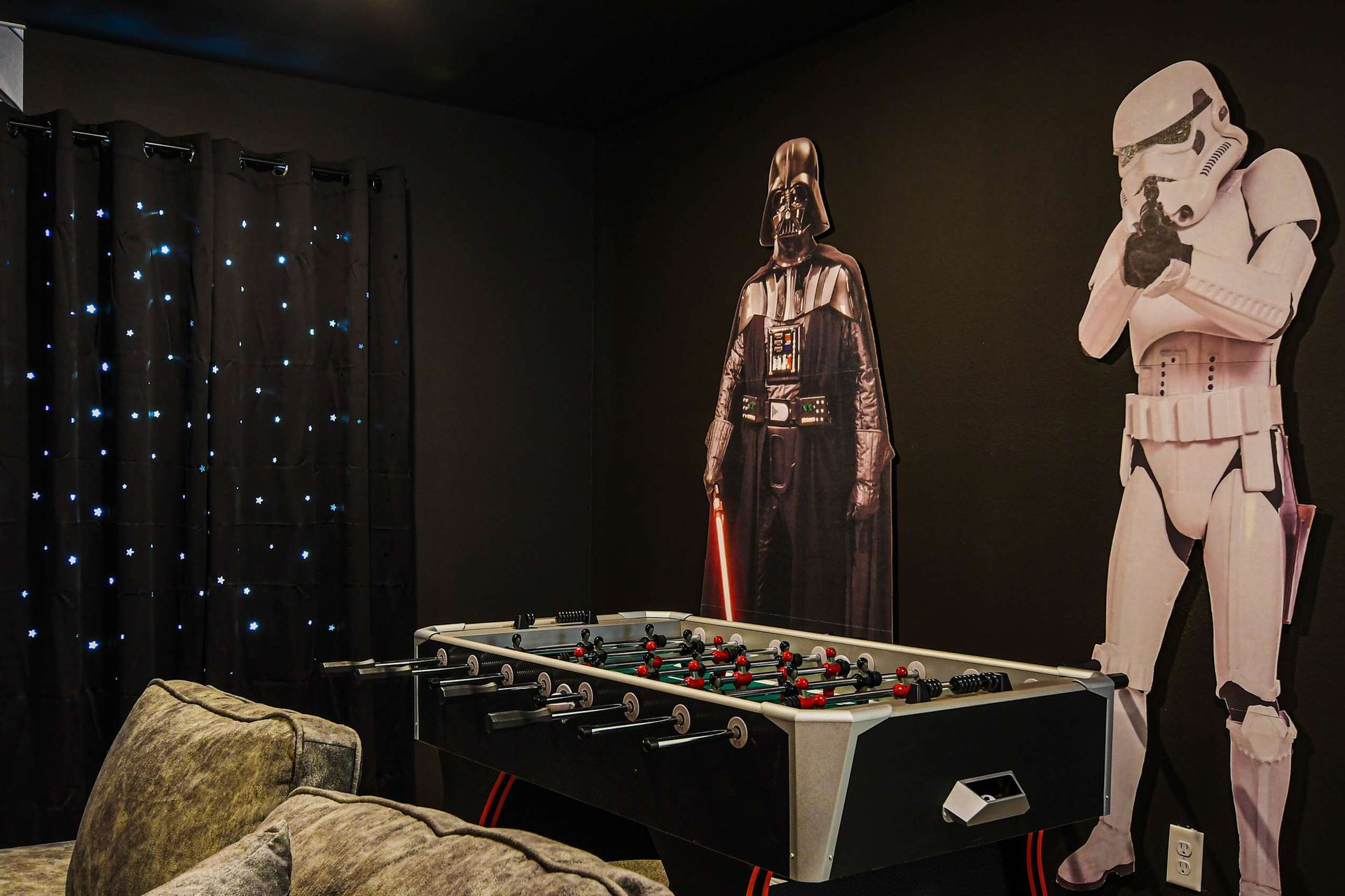 Immersive game room with foosball, galaxy lights, and epic space adventure decor.