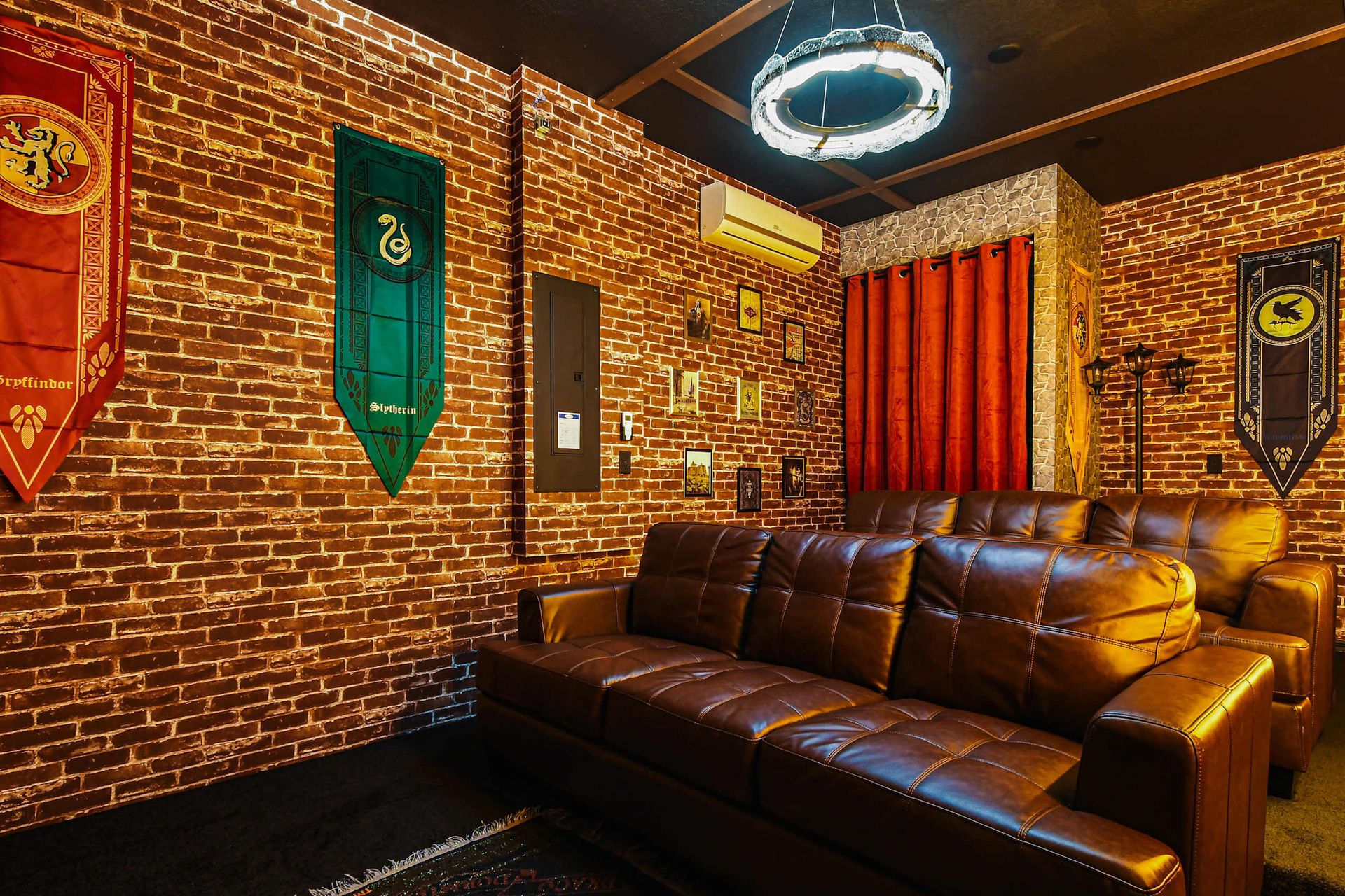 Enchanting movie room with house banners, cozy leather seating, and magical details.