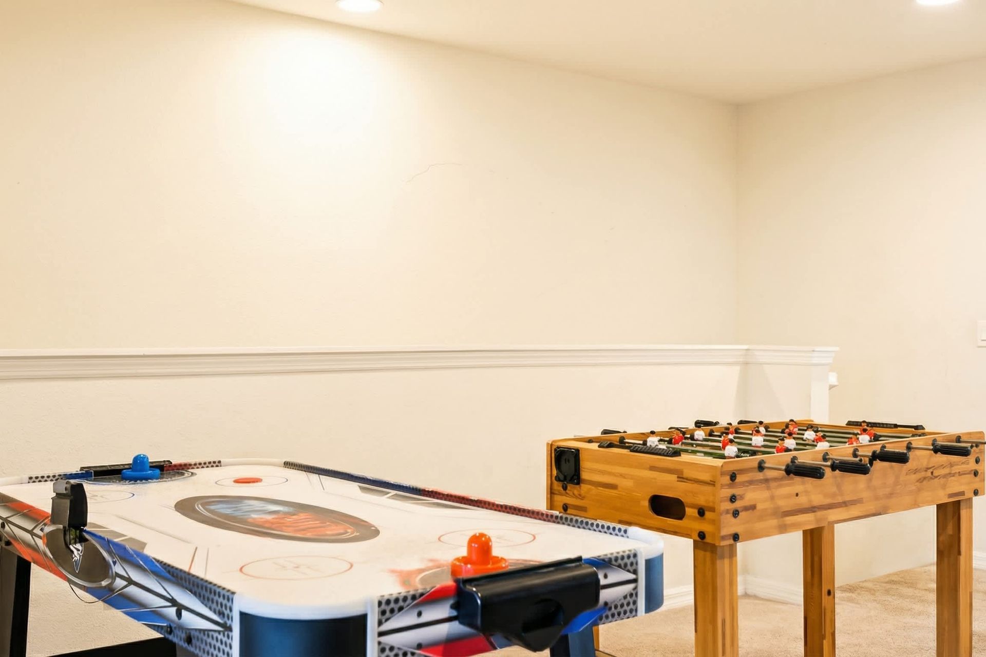 Fun upstairs game zone with air hockey and foosball, perfect for friendly matches.