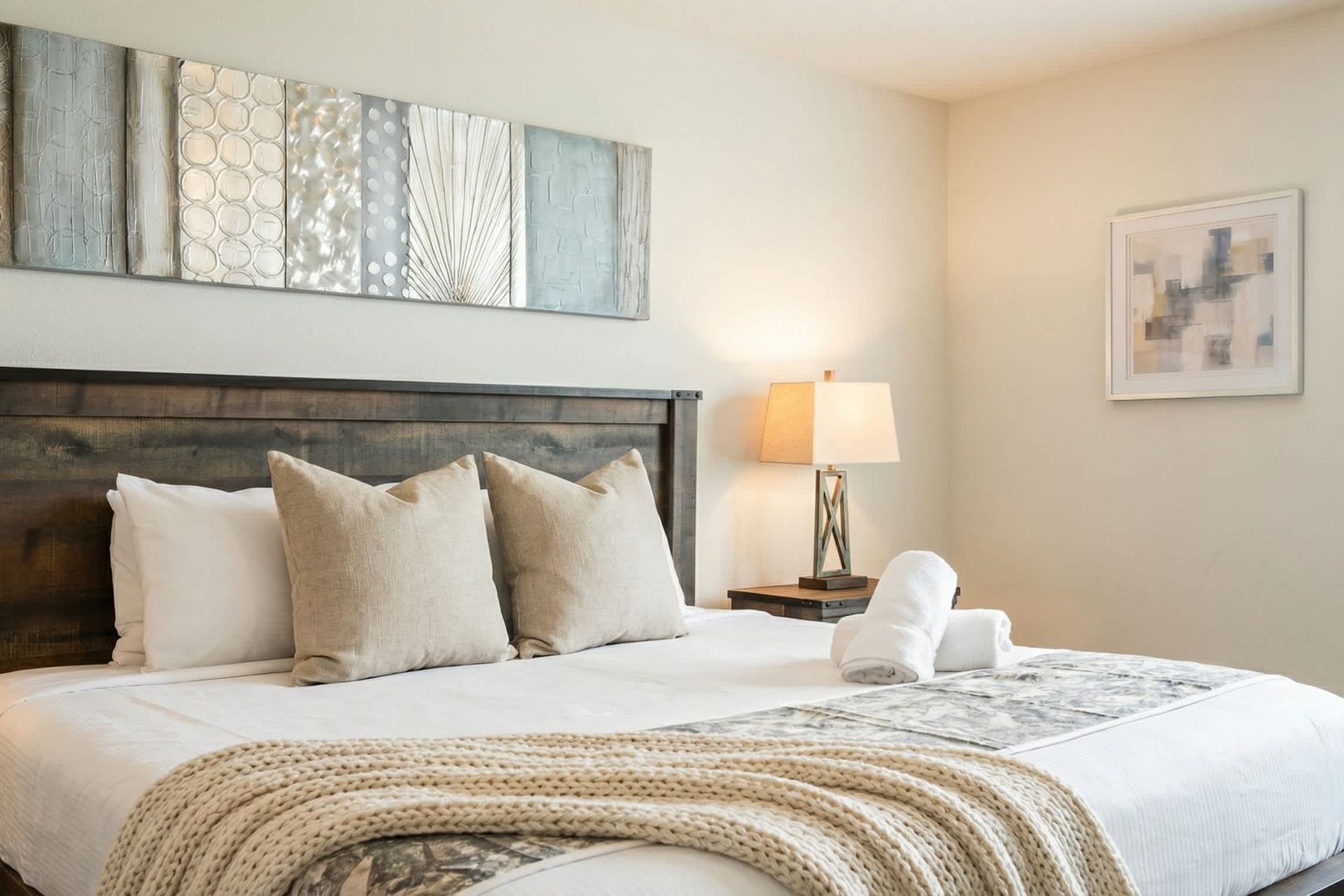 Spacious master suite with rustic king bed, cozy lighting, and private bathroom.