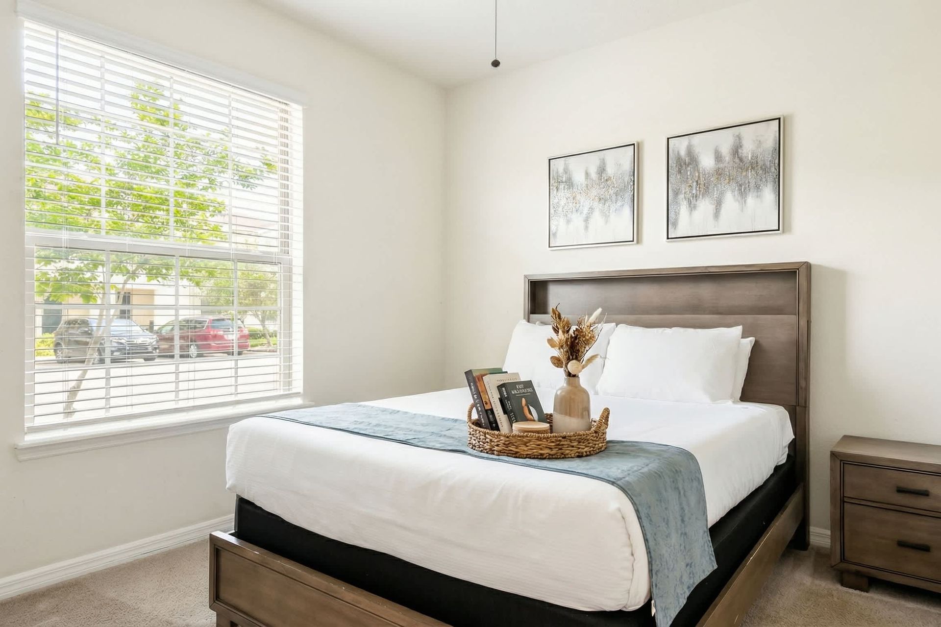 Bright and serene queen bedroom with modern décor and a peaceful street view.