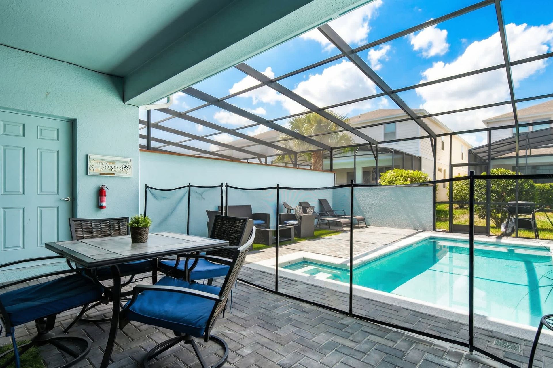 Covered outdoor dining by the private pool, complete with loungers and safety fence.