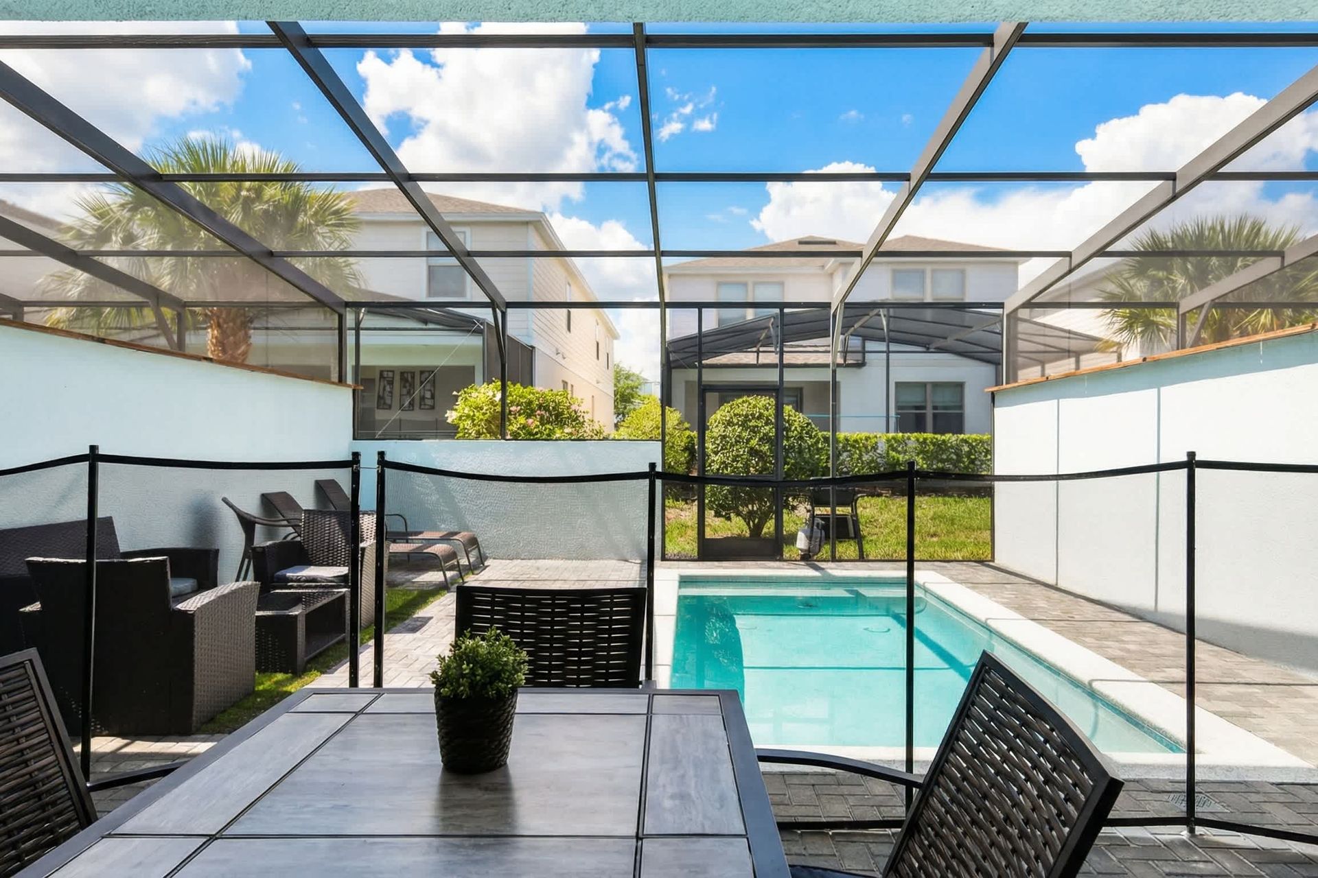 Enjoy private outdoor dining and a sunny screened pool with loungers and seating.