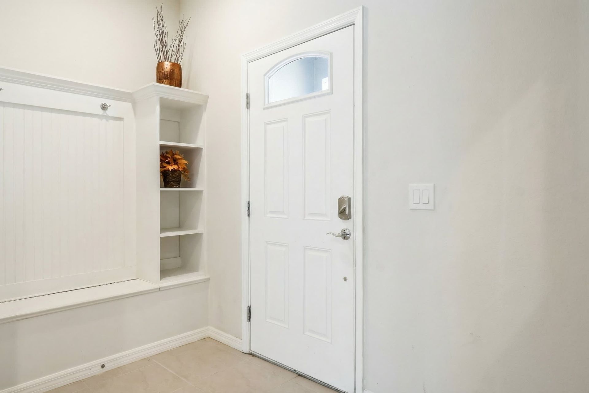 Inviting front entryway with built-in shelves and a cozy decorative touch.