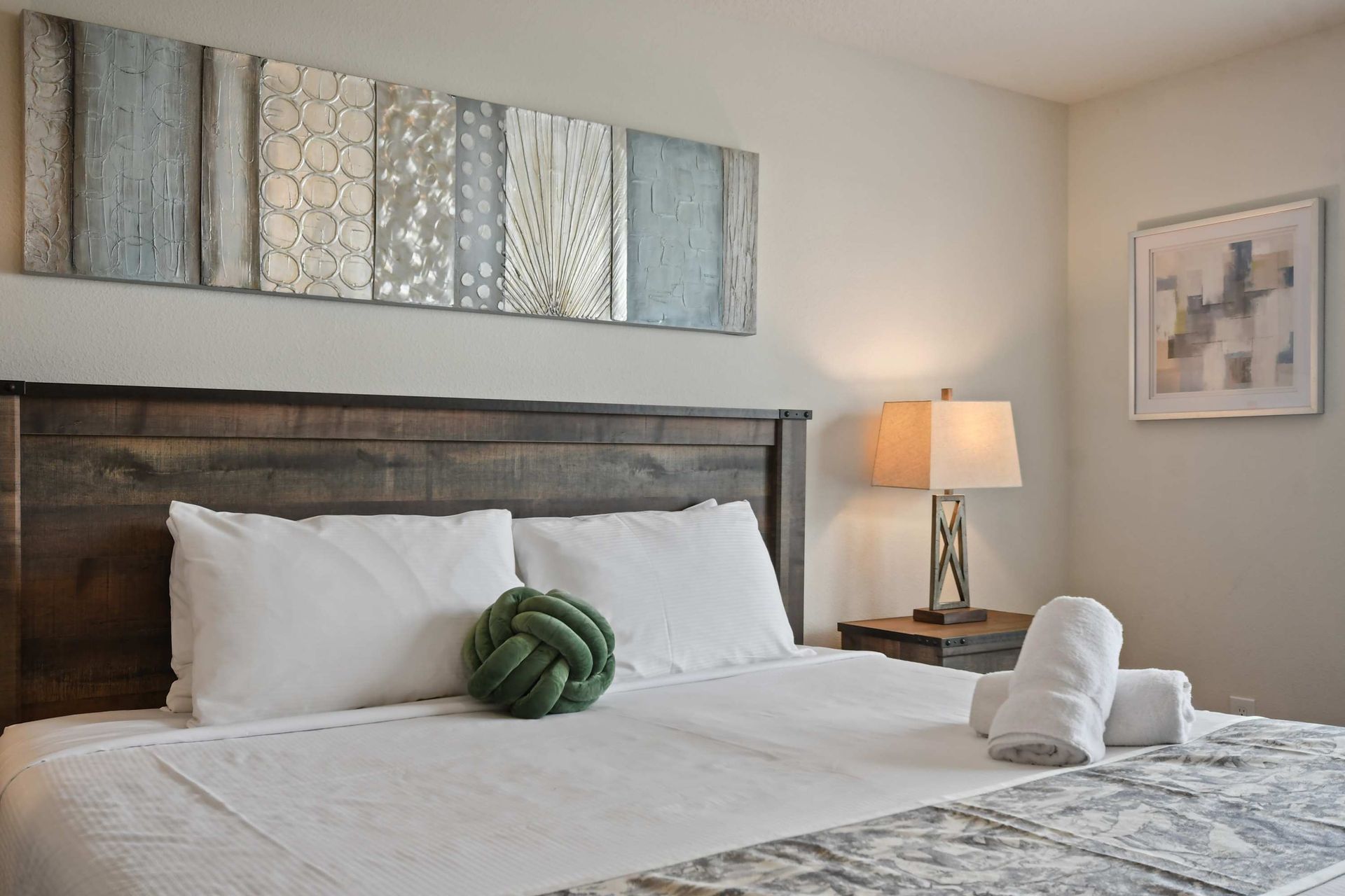 Spacious master suite with rustic king bed, cozy lighting, and private bathroom.