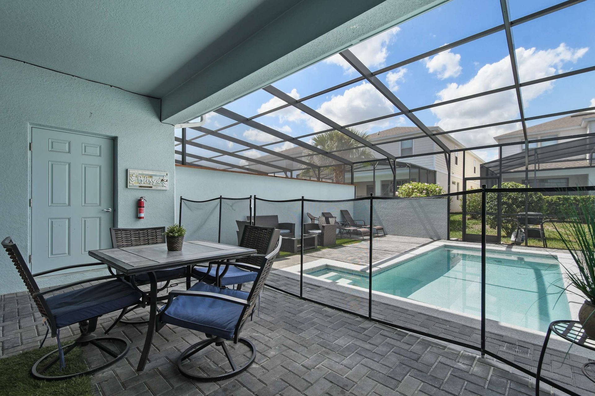 Covered outdoor dining by the private pool, complete with loungers and safety fence.