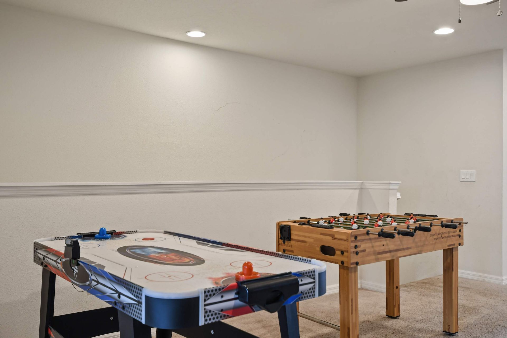 Fun upstairs game zone with air hockey and foosball, perfect for friendly matches.