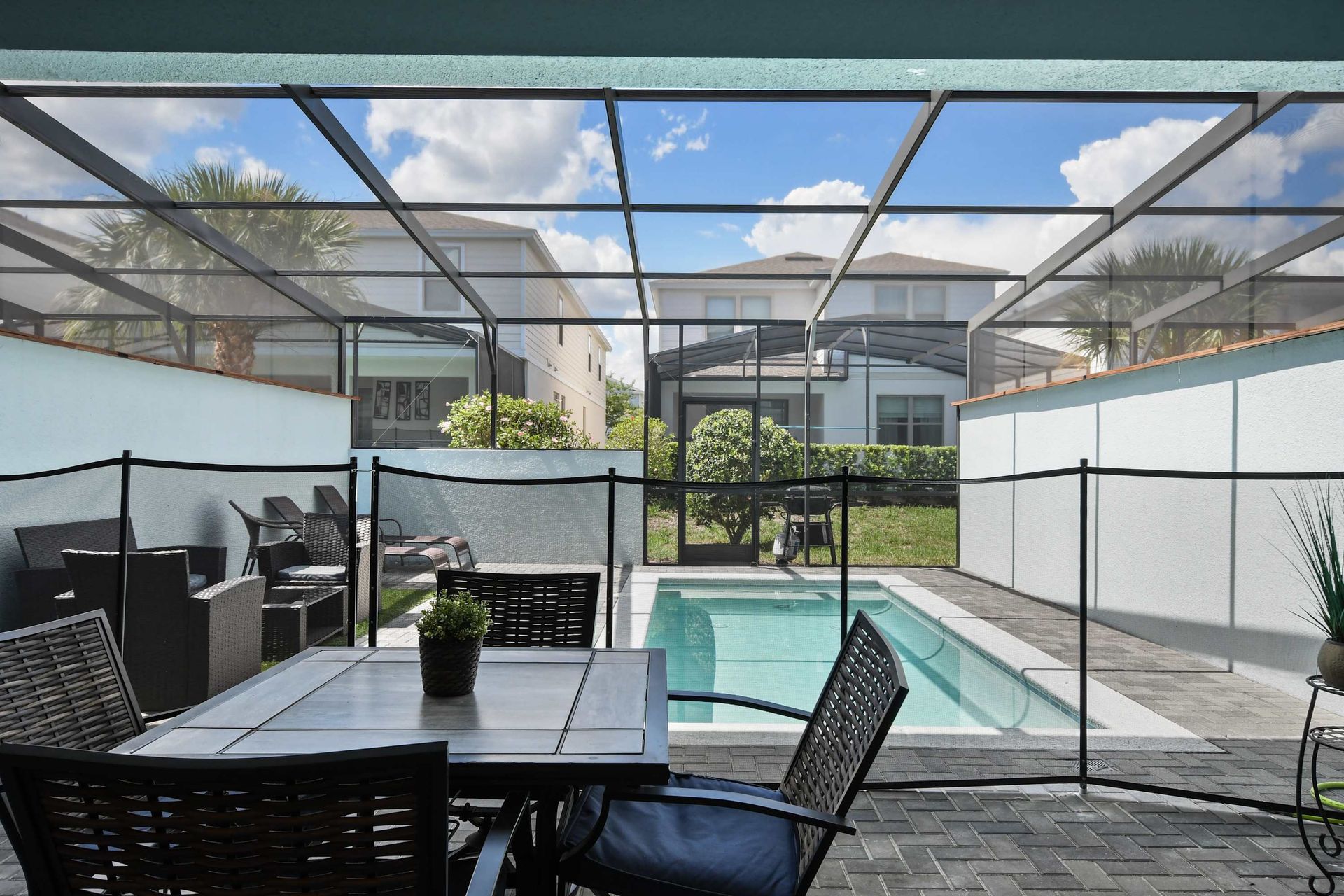 Enjoy private outdoor dining and a sunny screened pool with loungers and seating.