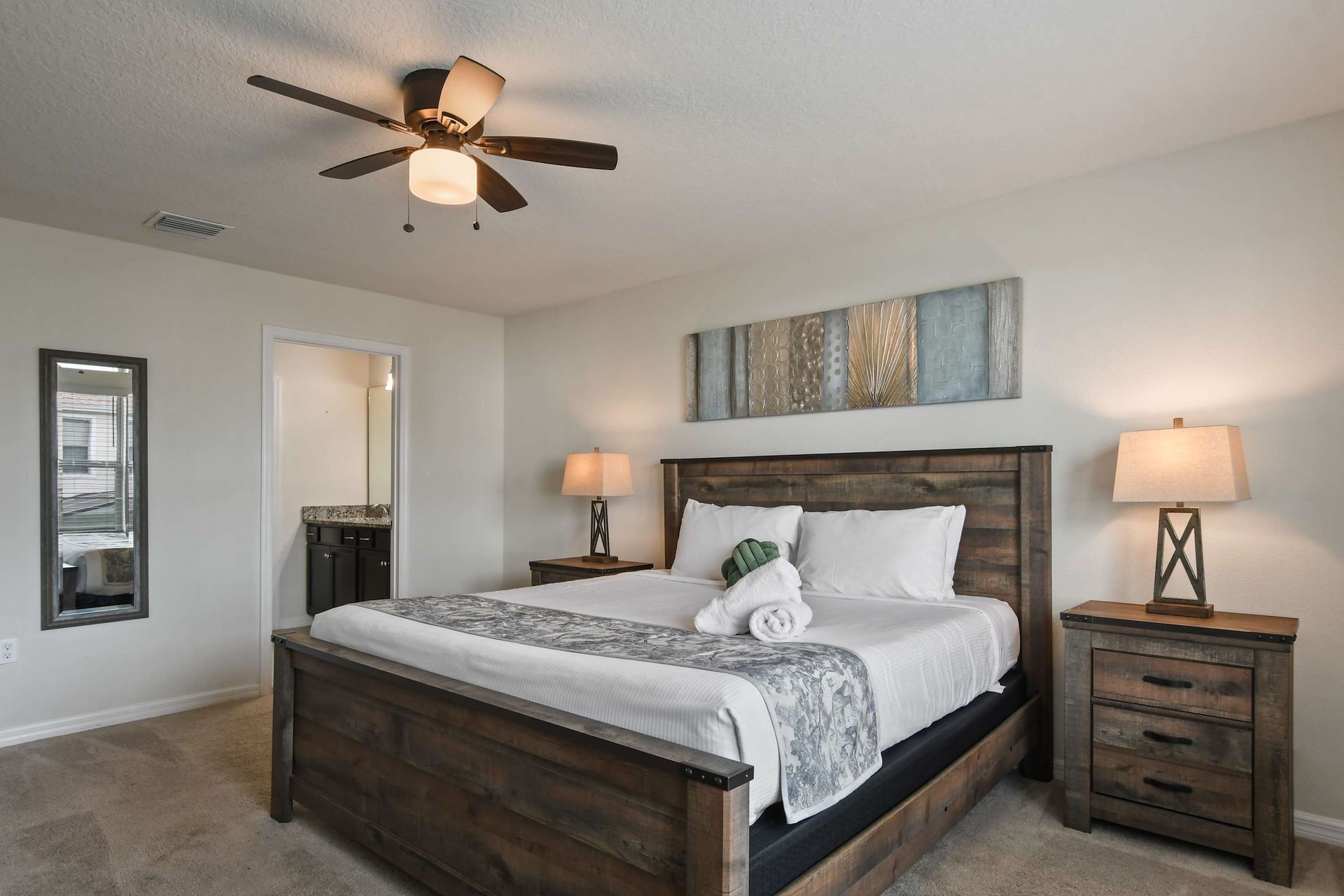 Spacious master suite with rustic king bed, cozy lighting, and private bathroom.