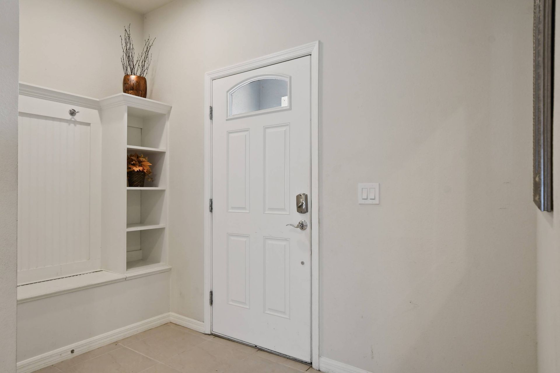 Inviting front entryway with built-in shelves and a cozy decorative touch.