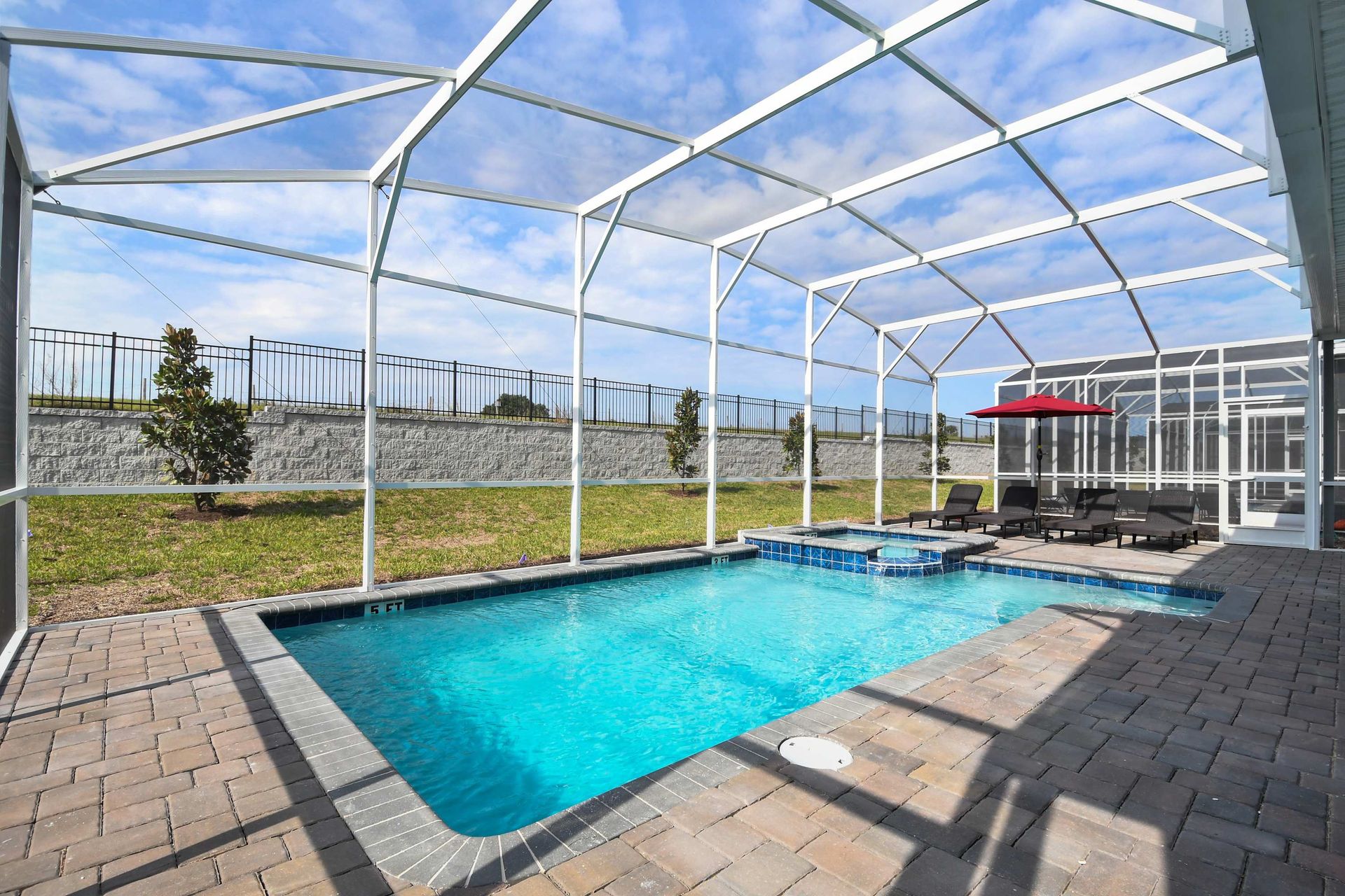 Private screened pool with spa, sunny loungers, and peaceful outdoor vibes.
