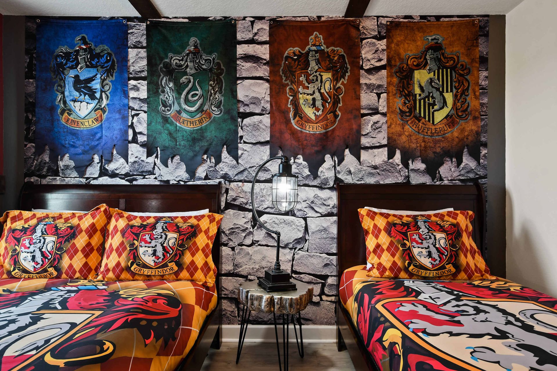 Wizarding-themed twin room with house banners, castle art, and magical charm.