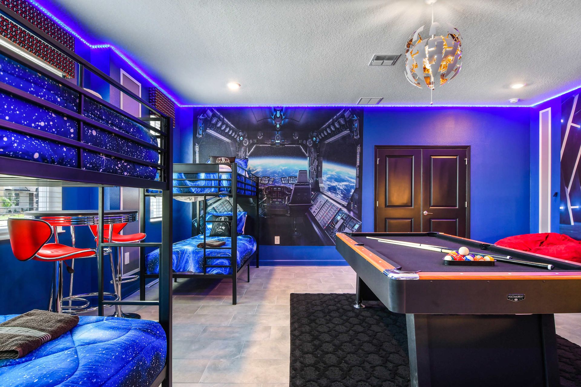 Galactic-themed game room with bunk beds, pool table, and LED mood lighting.