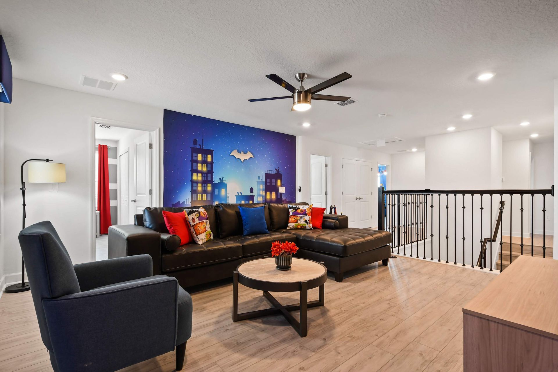 Upstairs hero-themed loft with comfy sectional, cityscape mural, and TV lounge.
