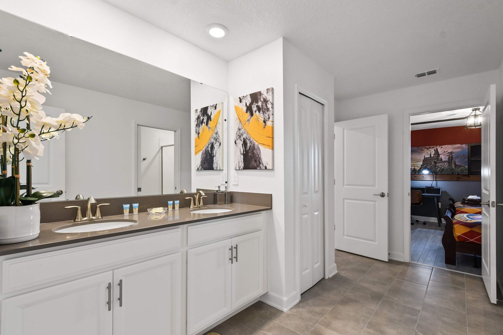 Spacious double sink bathroom with modern design and themed bedroom access.