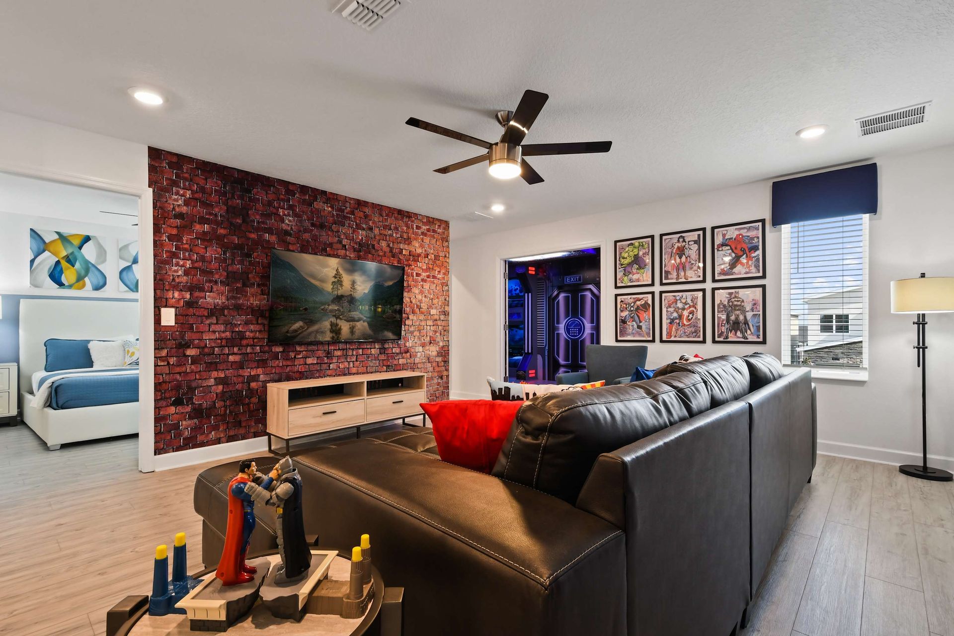 Cozy hero-themed loft with leather sectional, brick accent wall, and smart TV.