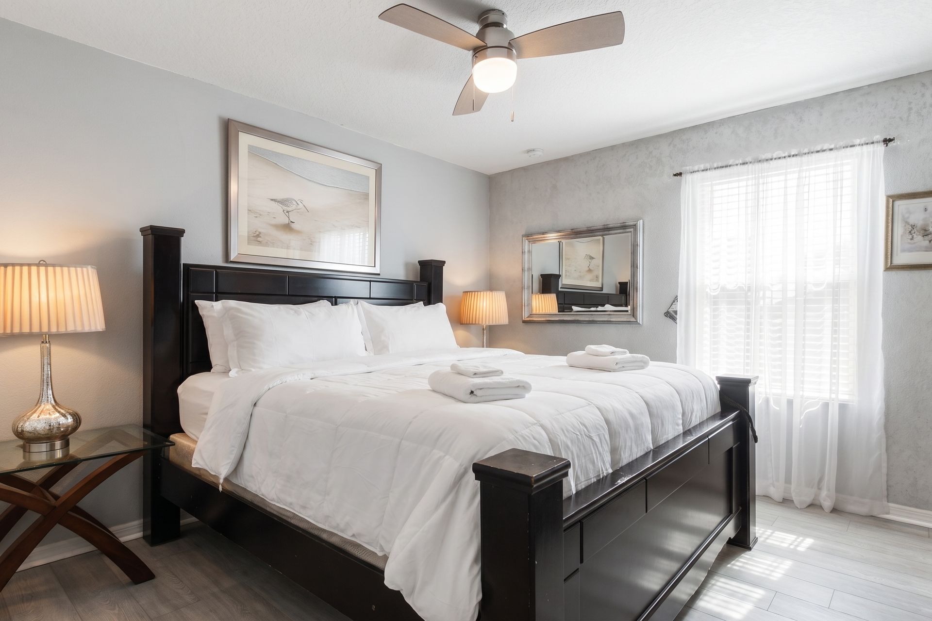 Elegant master bedroom with plush bedding, warm lighting, and charm!