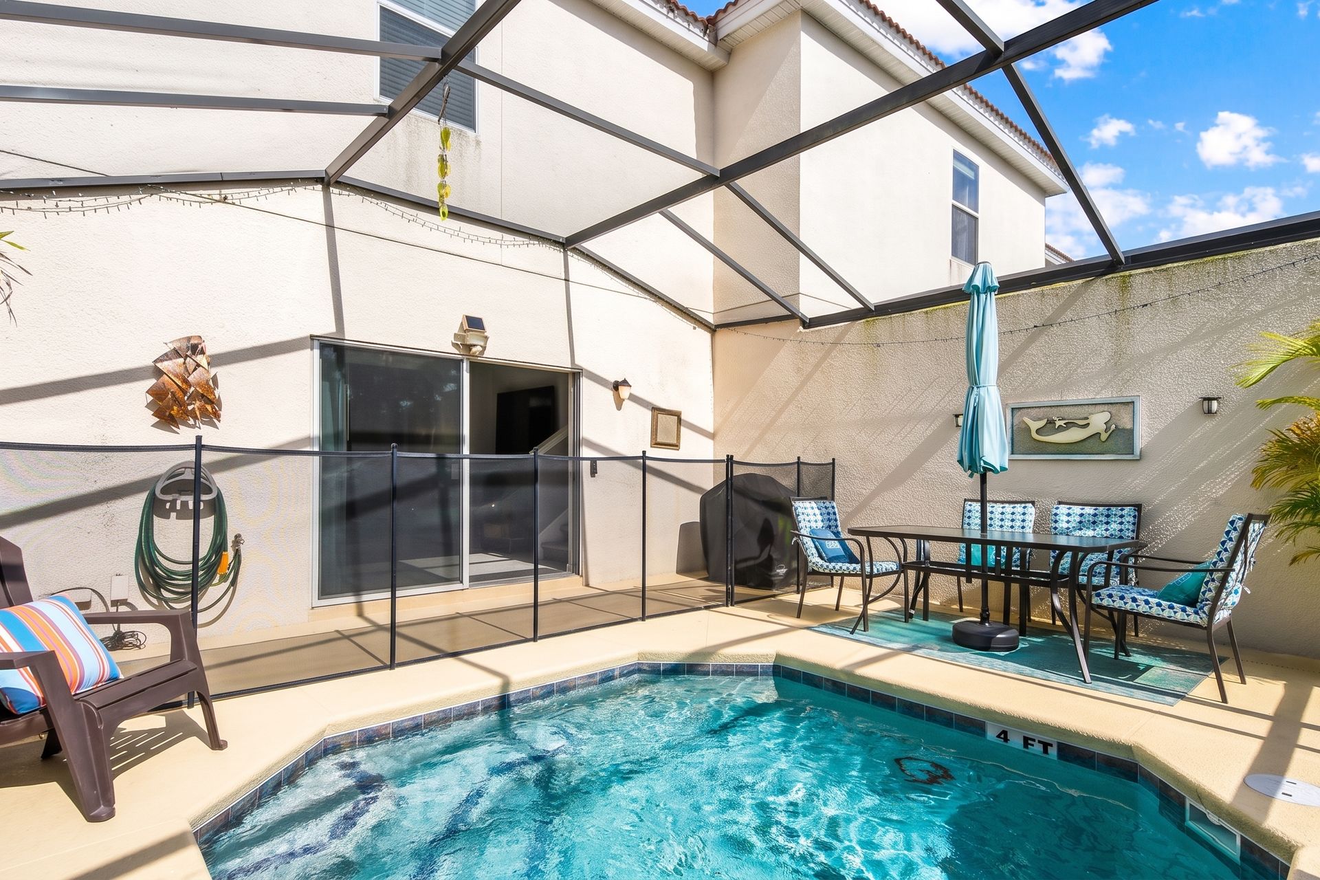 Inviting pool area with safety fencing, cozy seating, and decor!