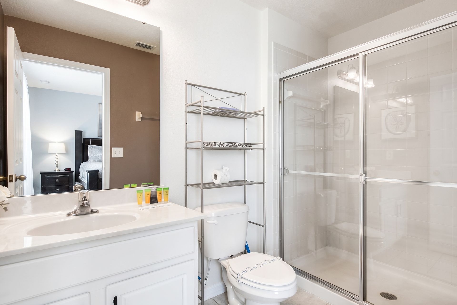 Spacious bathroom with a walk-in shower, modern storage, and essentials!