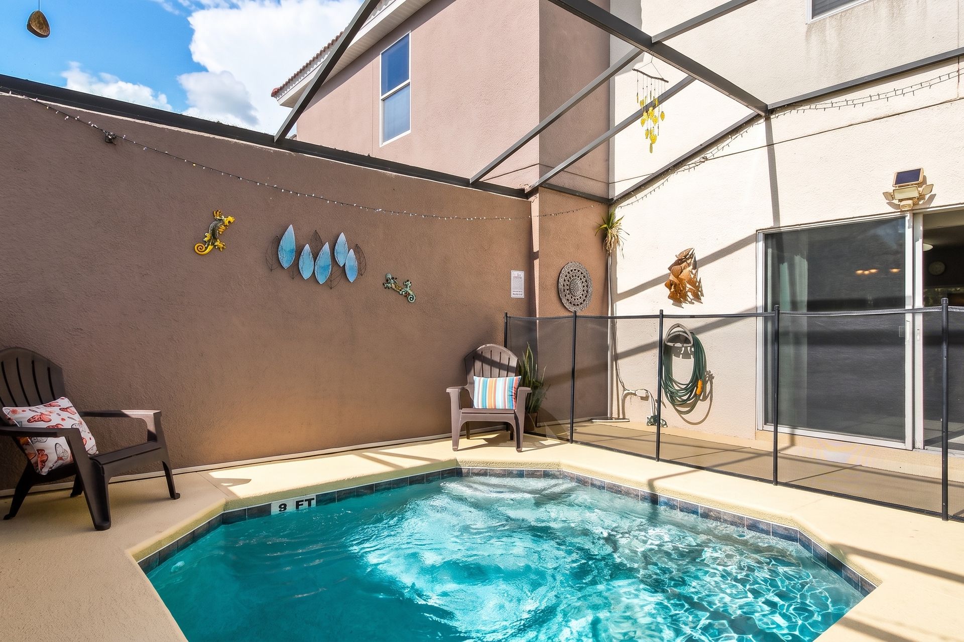 Inviting pool area with safety fencing, cozy seating, and decor!