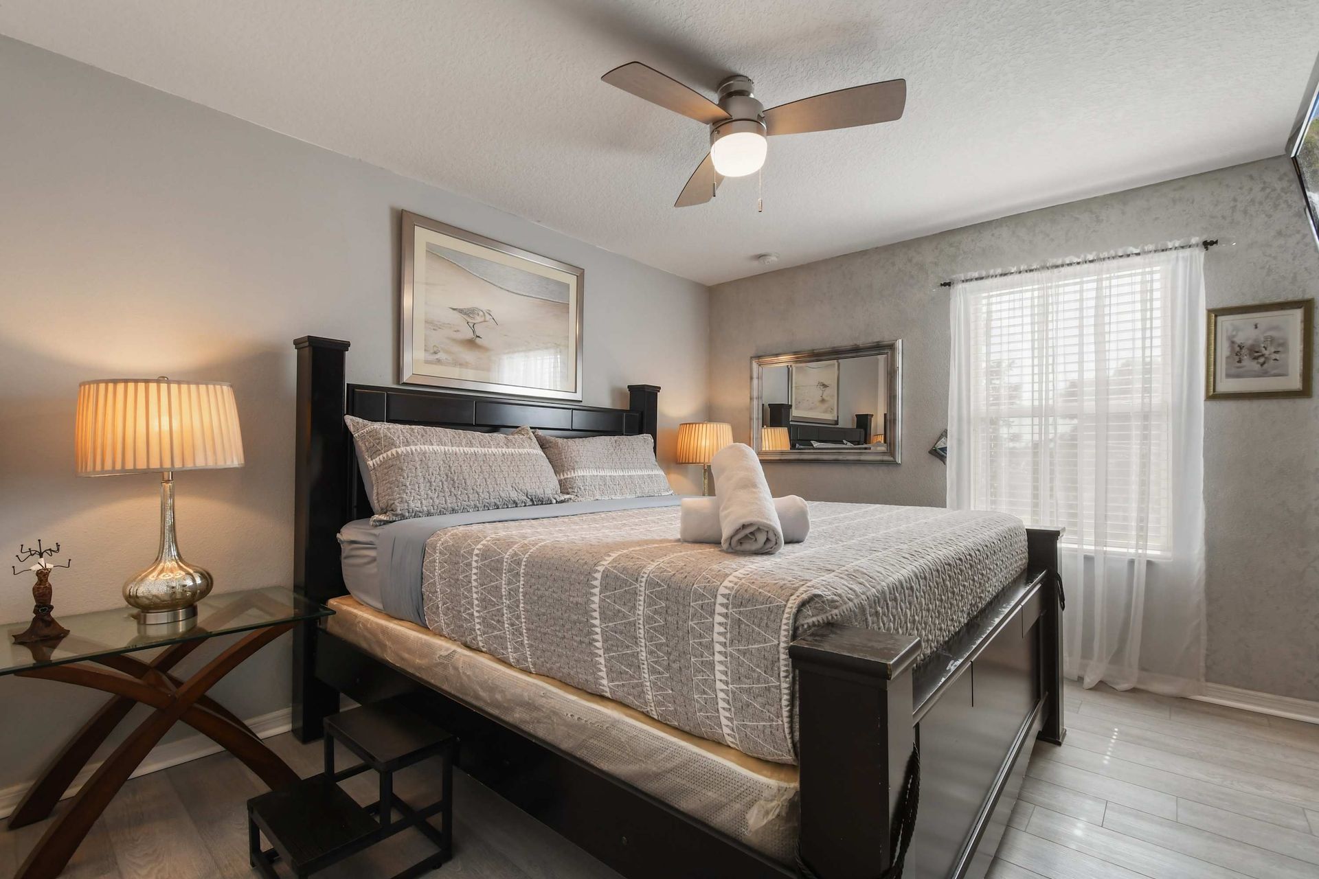 Elegant master bedroom with plush bedding, warm lighting, and charm!