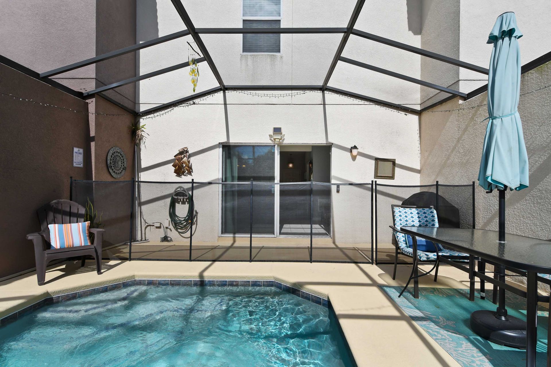Inviting pool area with safety fencing, cozy seating, and decor!