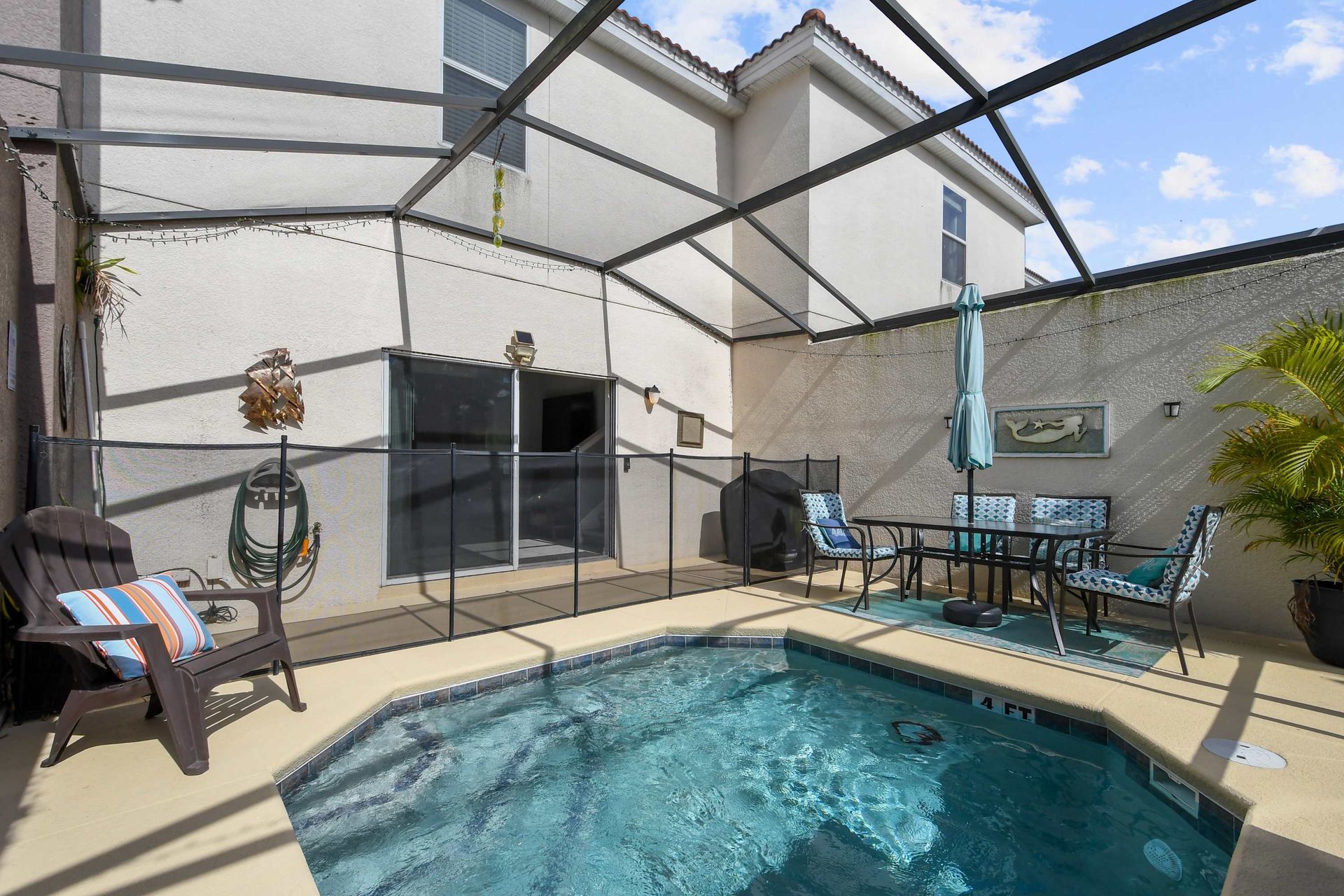 Inviting pool area with safety fencing, cozy seating, and decor!