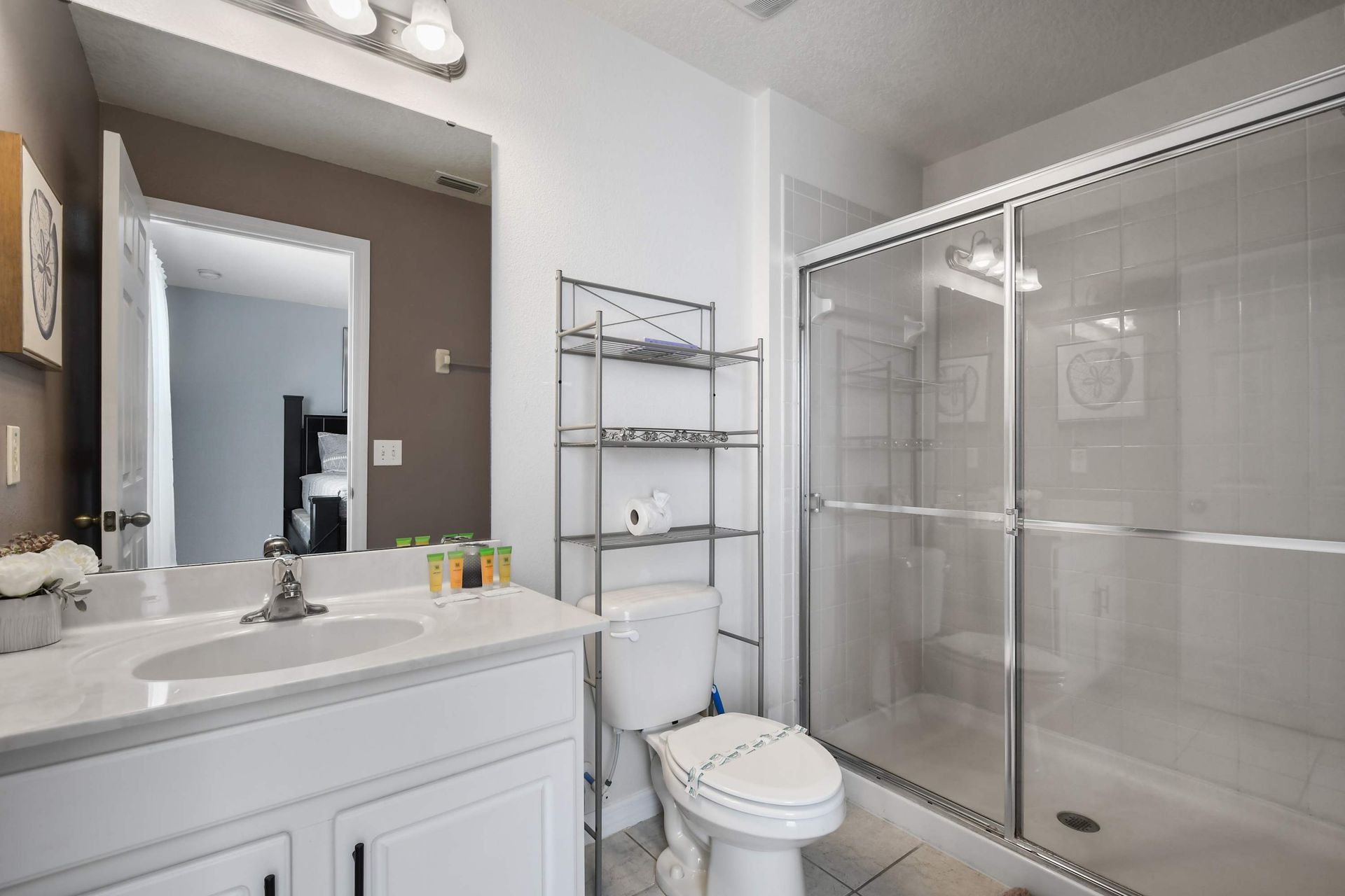 Spacious bathroom with a walk-in shower, modern storage, and essentials!