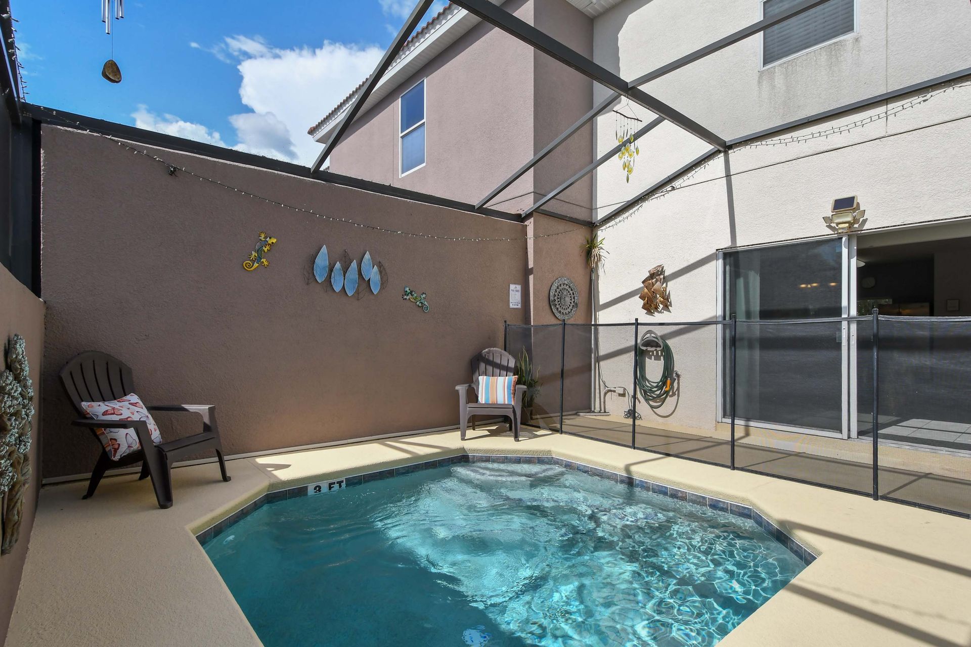 Inviting pool area with safety fencing, cozy seating, and decor!