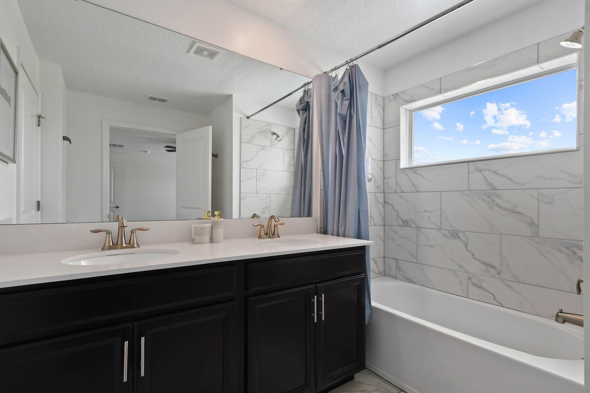 Modern Bathroom w/ Dual Sinks, Marble Tile & Bright Natural Light!