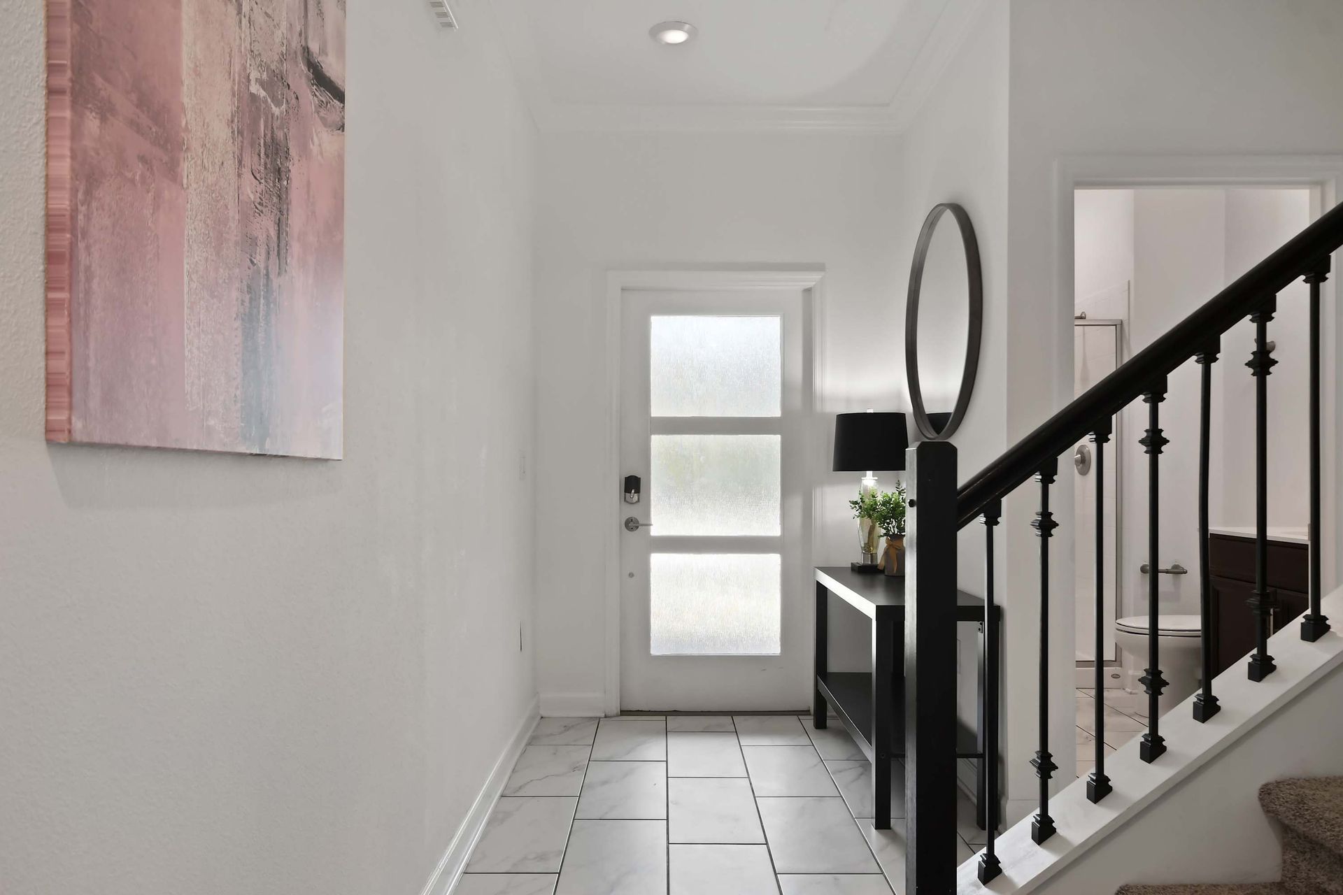 Inviting Entryway with Modern Décor, Sleek Railings & Natural Light!