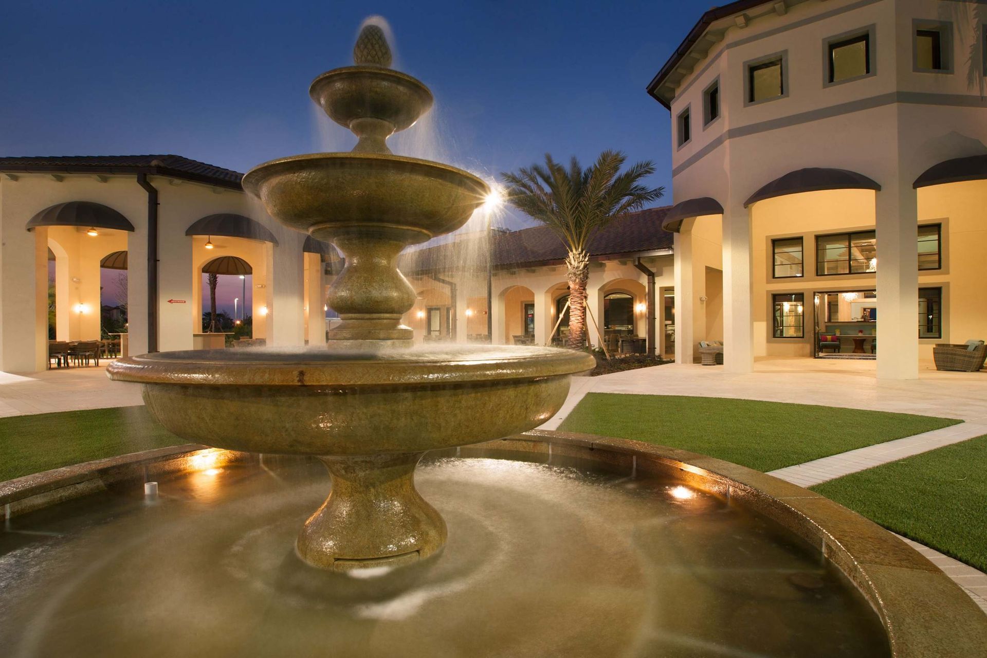 Elegant night ambiance with a glowing fountain and clubhouse!