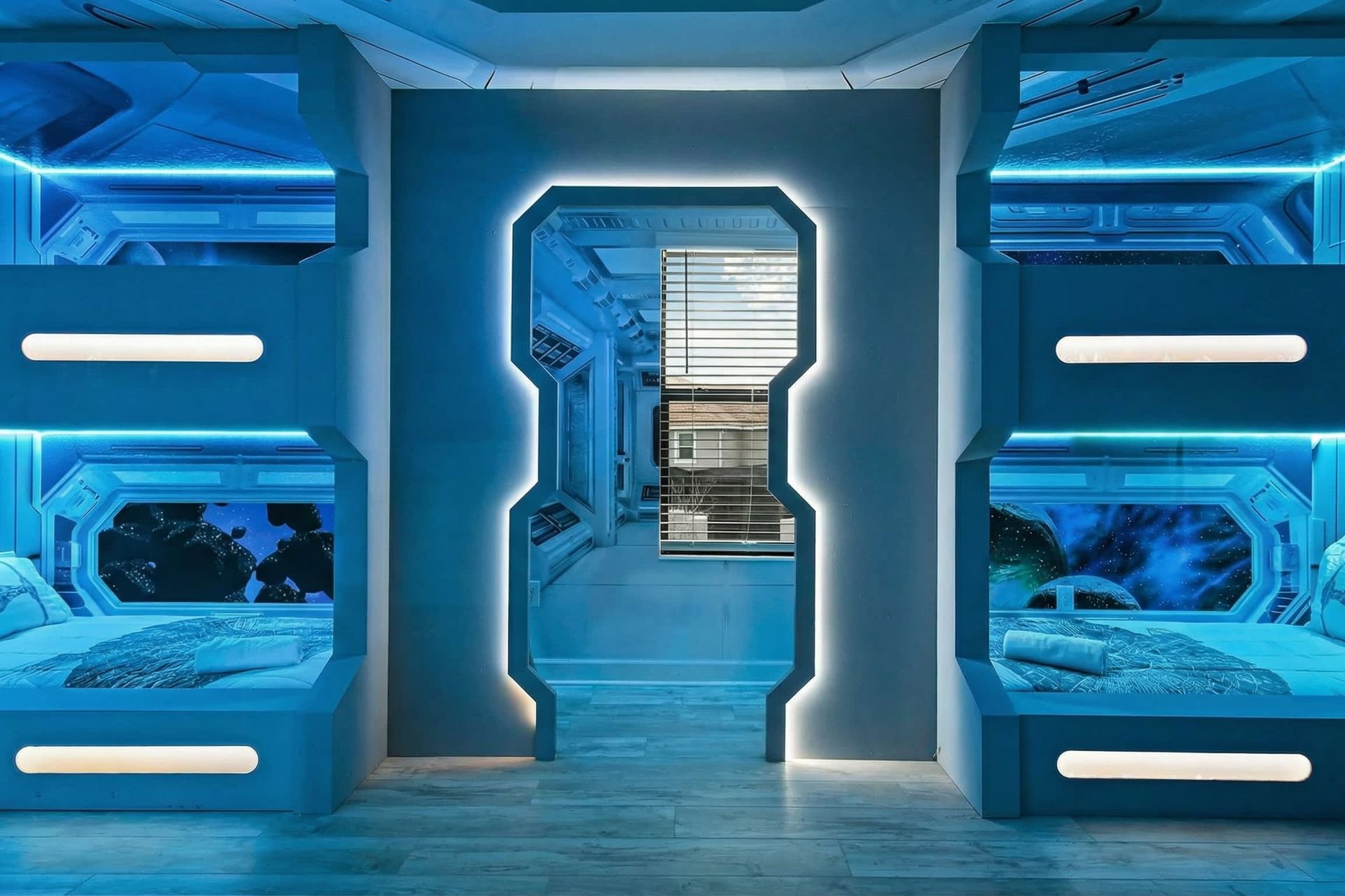 Futuristic space-themed bunk room with glowing blue lights and immersive galactic décor.
