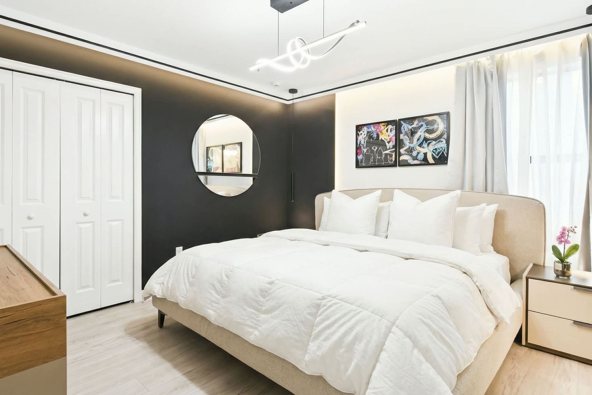Sophisticated bedroom with a plush king bed, bold décor, and sleek modern lighting.