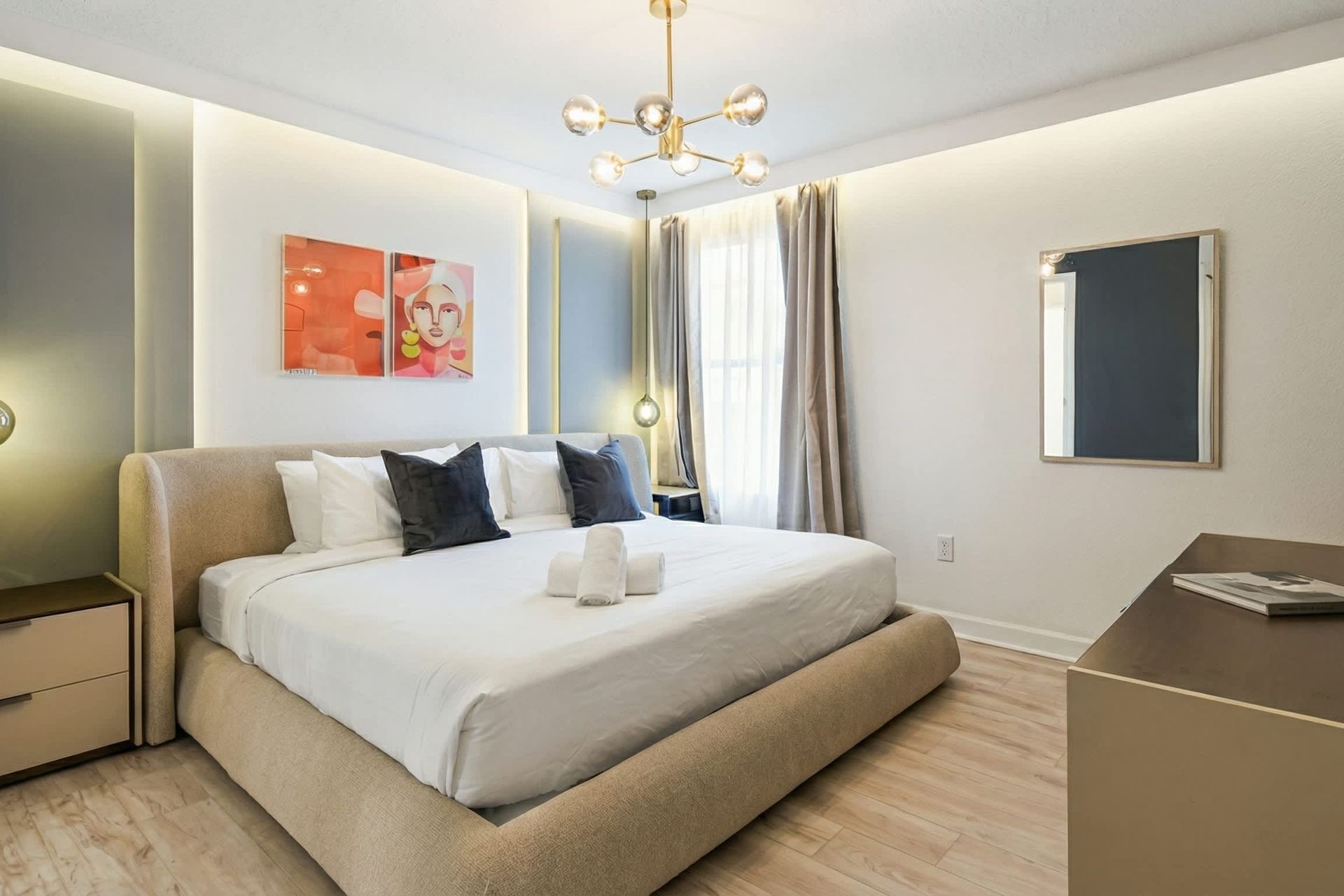 Stylish bedroom with a plush king bed, modern lighting, and chic artistic décor.