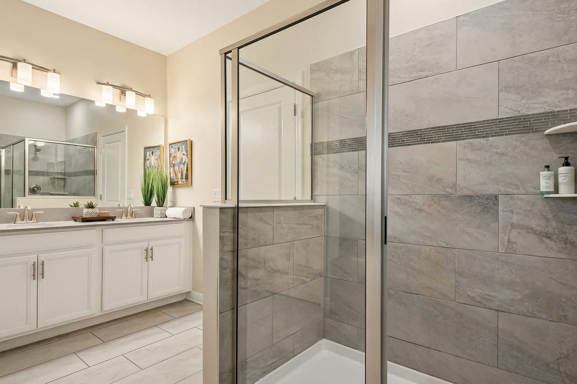 Spacious modern bathroom with a glass-enclosed shower, dual vanity, and elegant décor.