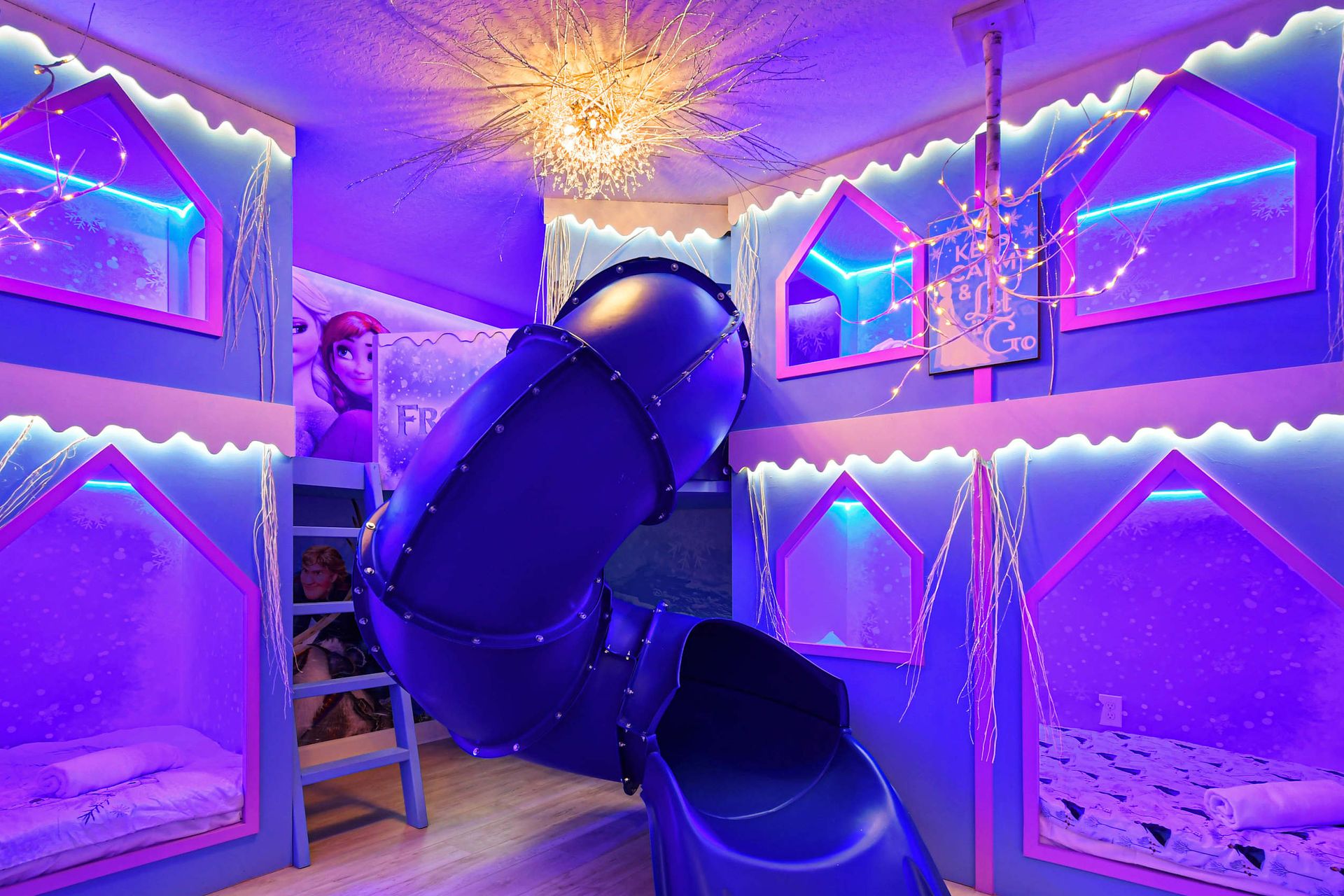 Magical winter-themed bunk room with glowing lights, an icy slide, and cozy beds.