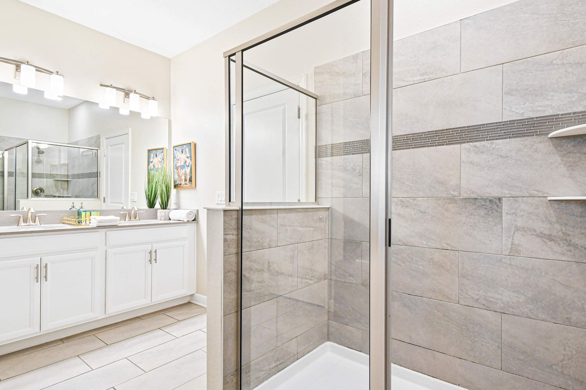 Spacious modern bathroom with a glass-enclosed shower, dual vanity, and elegant décor.