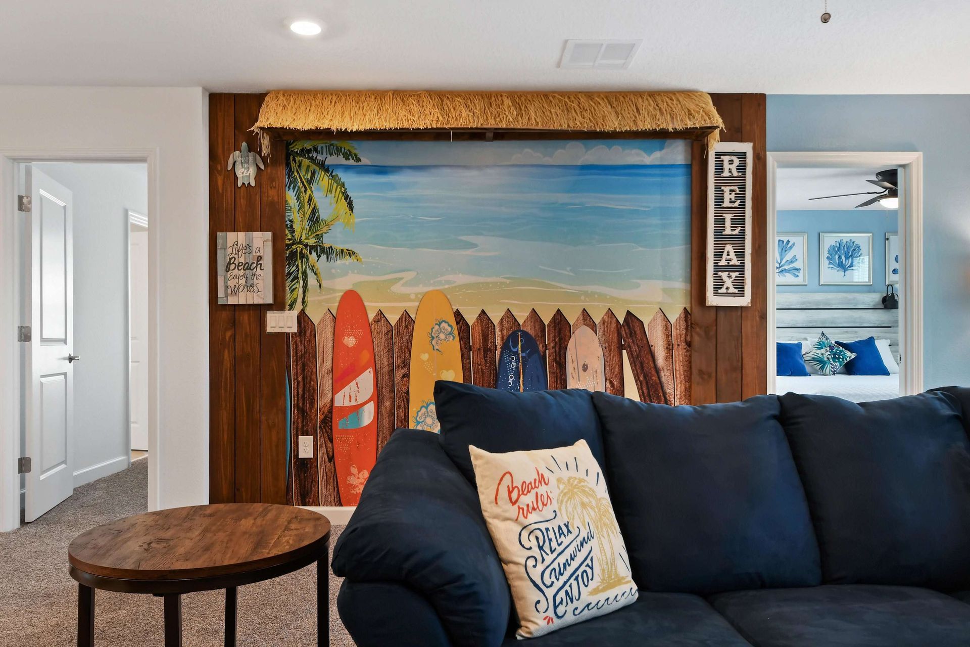 Tropical-themed lounge with vibrant decor, cozy seating, and a stunning beach mural.